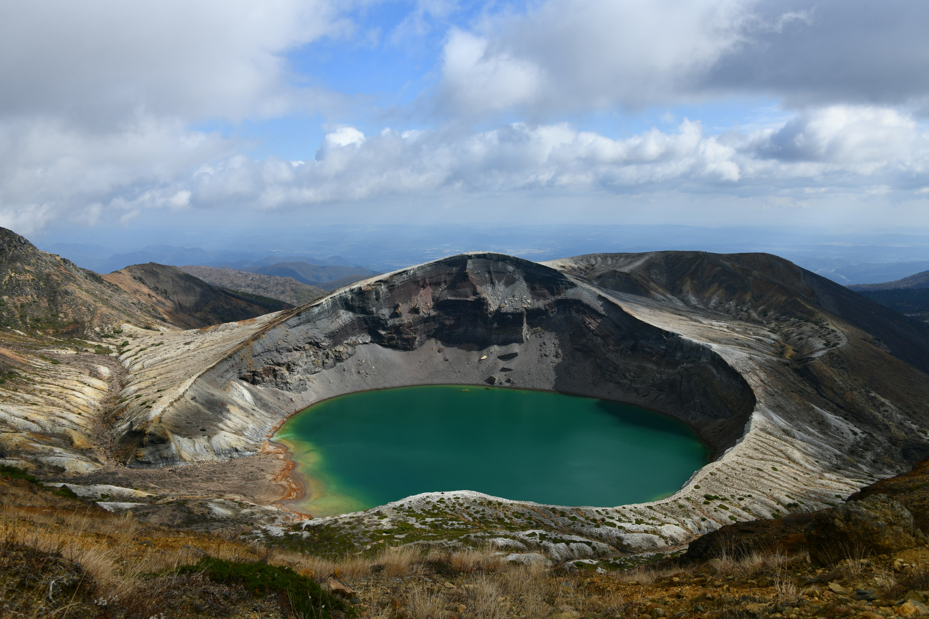 Impresionante vista de un lago volcánico con agua turquesa y montañas escarpadas