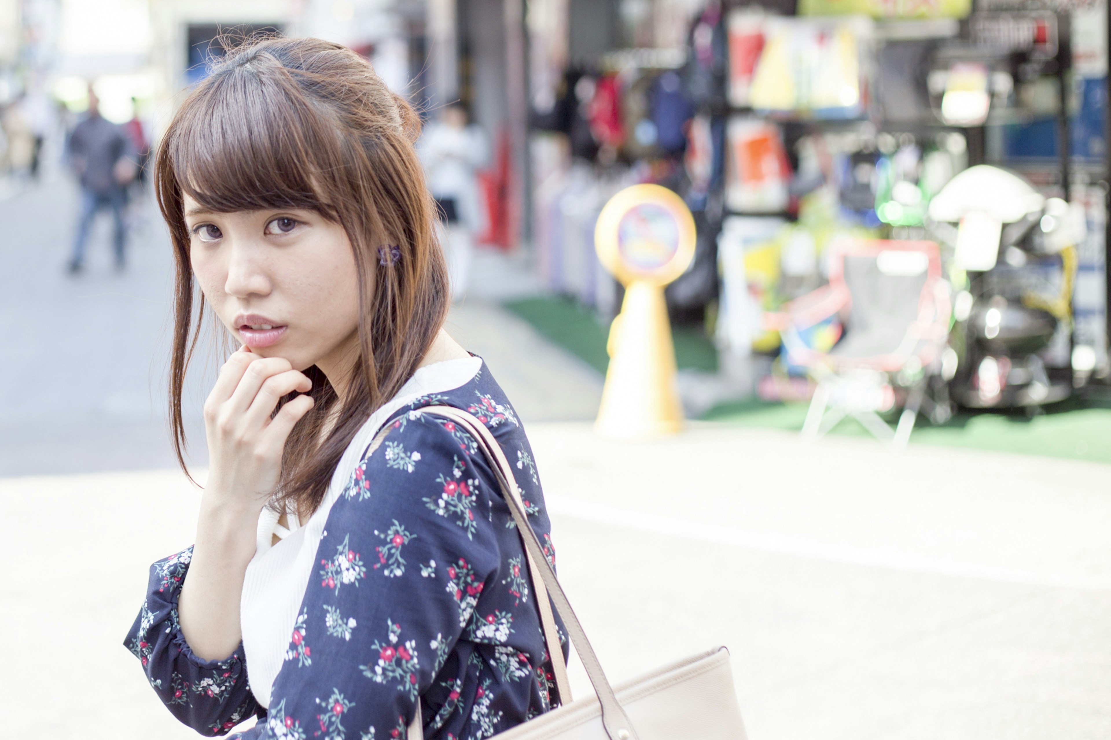 A woman in floral attire standing in a street scene