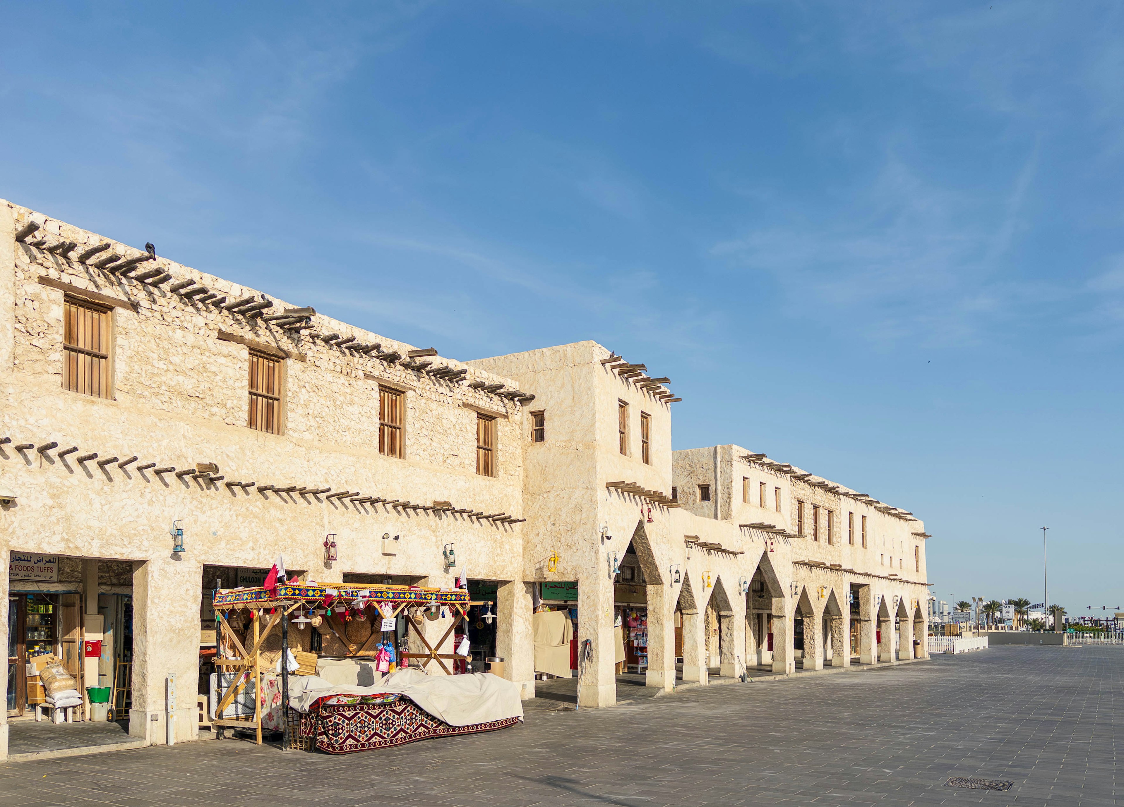 Scena di mercato con architettura araba tradizionale sotto un cielo blu