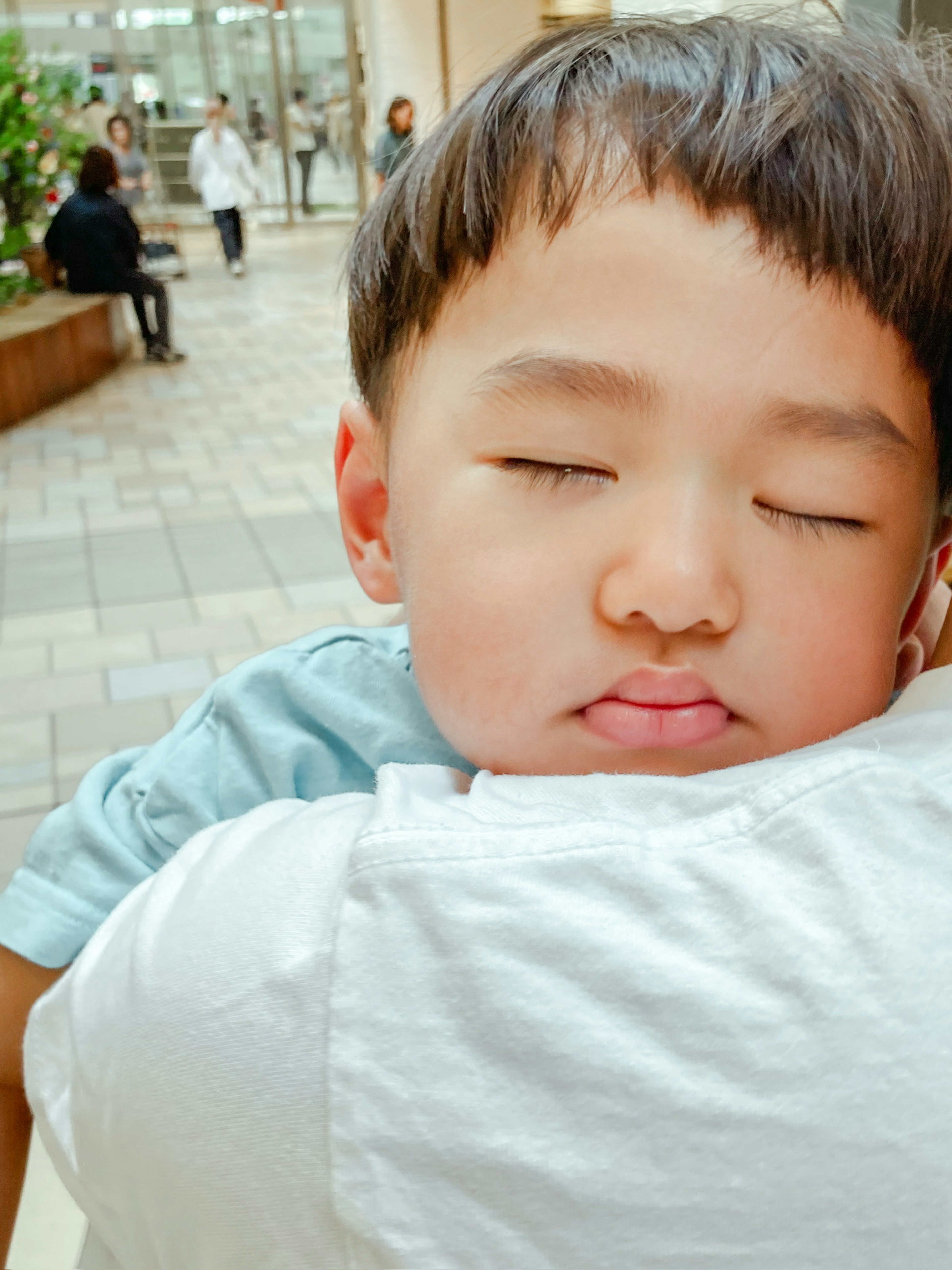 Un niño dormido en brazos con los ojos cerrados