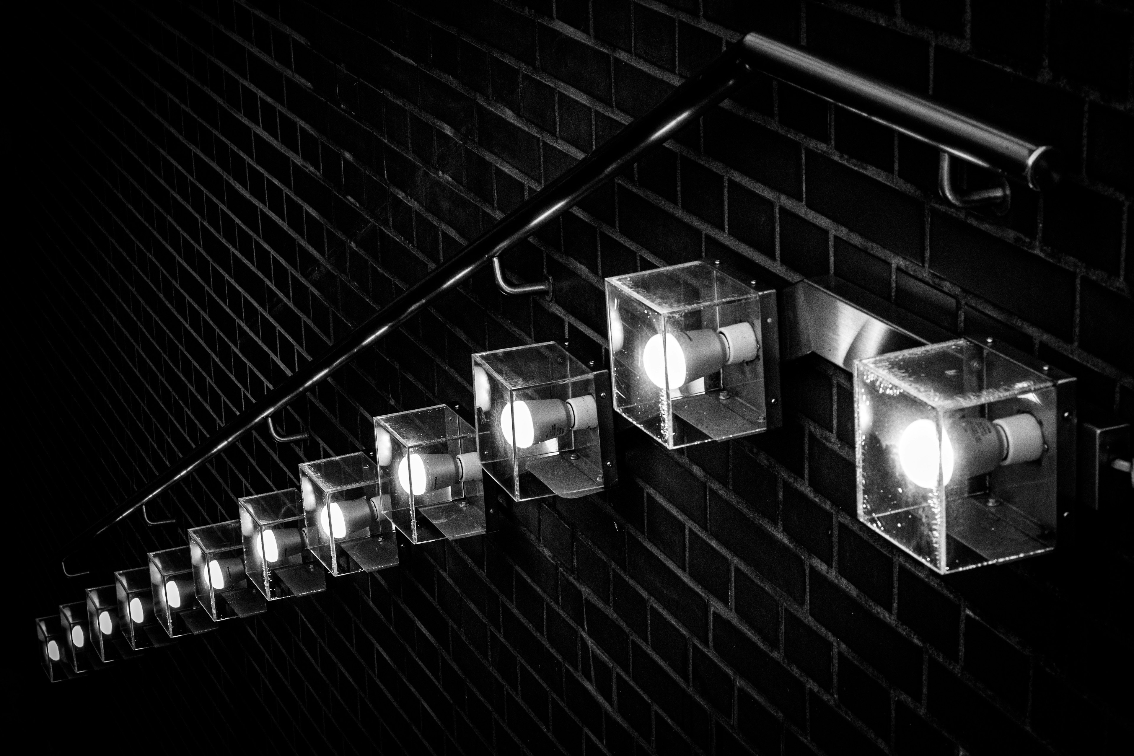 A staircase with transparent light boxes mounted on a black wall