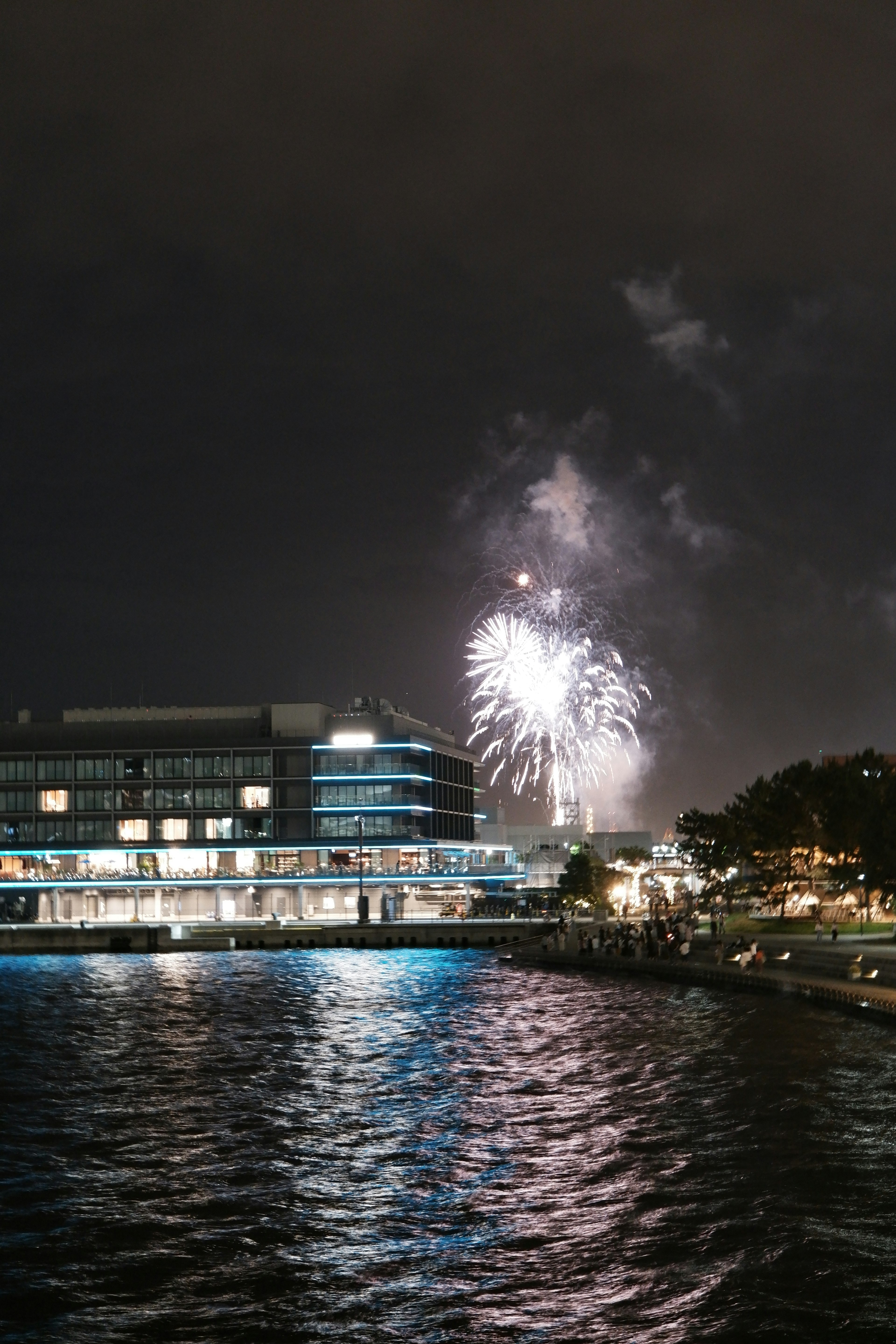 Schöne Szene mit Feuerwerk über dem Fluss bei Nacht