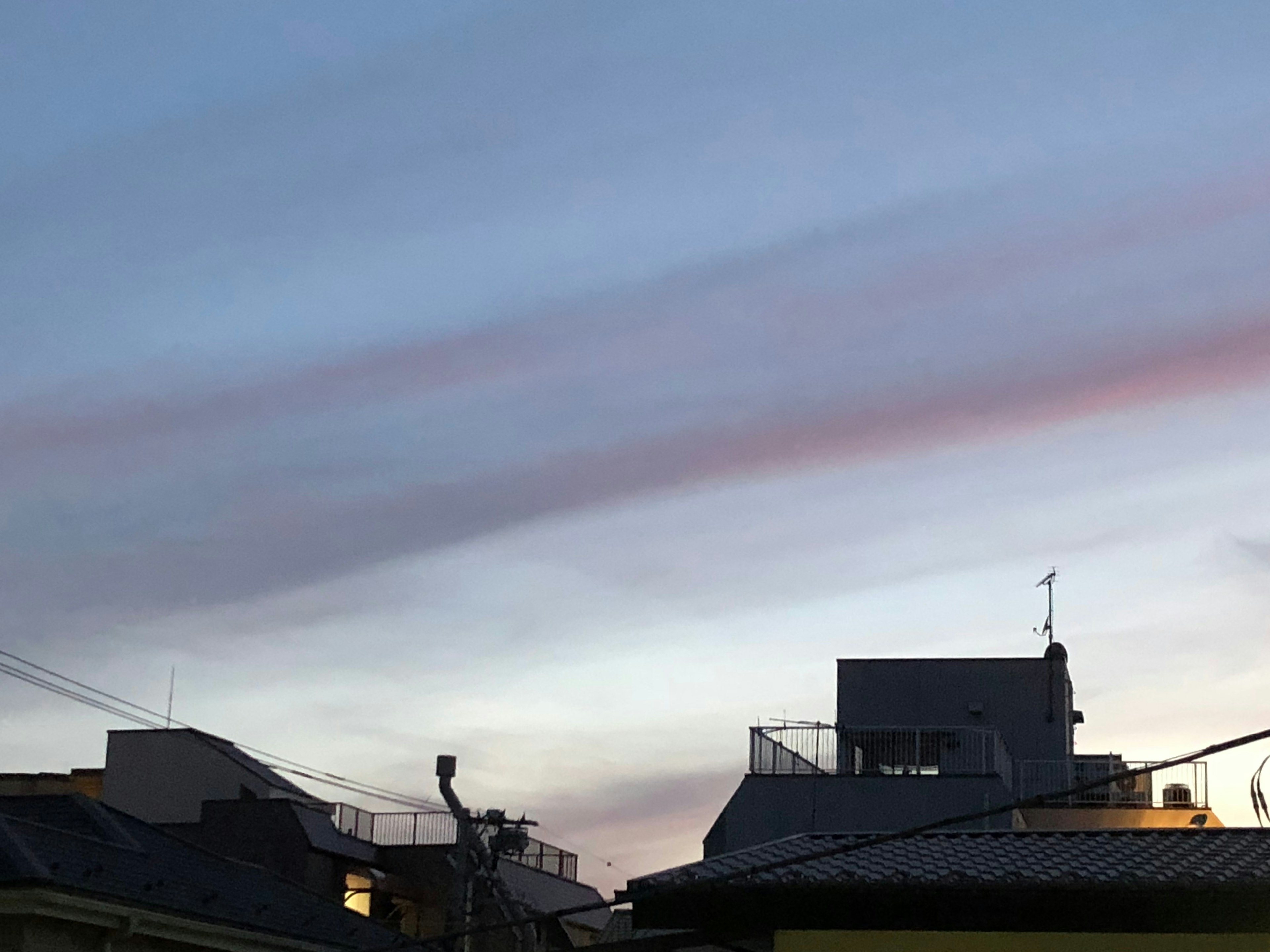 Schöne Wolken in der Dämmerung mit silhouettierten Gebäuden