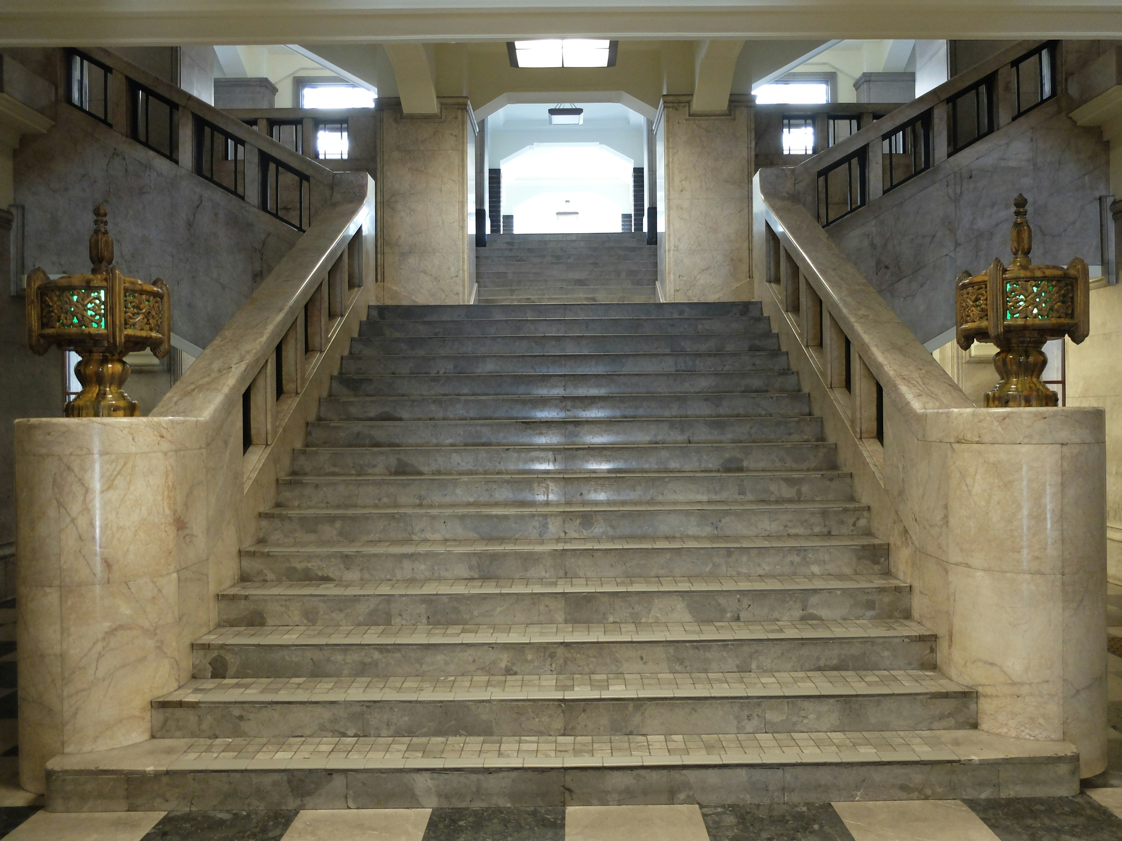 Elegante Treppe mit dekorativen Lampen und Marmorstufen