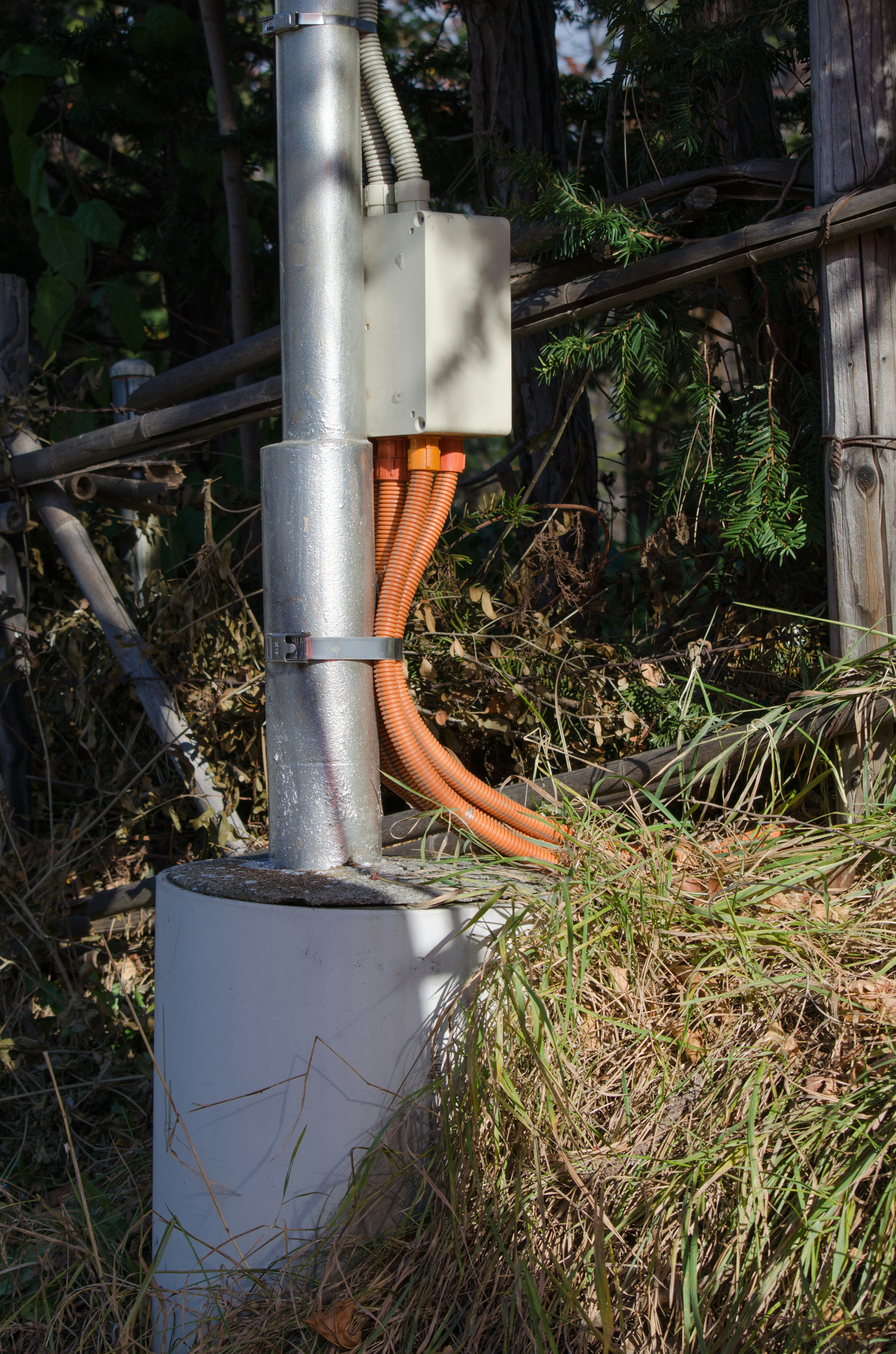 Foto de un tubo de metal con cables naranjas conectados a una caja de control