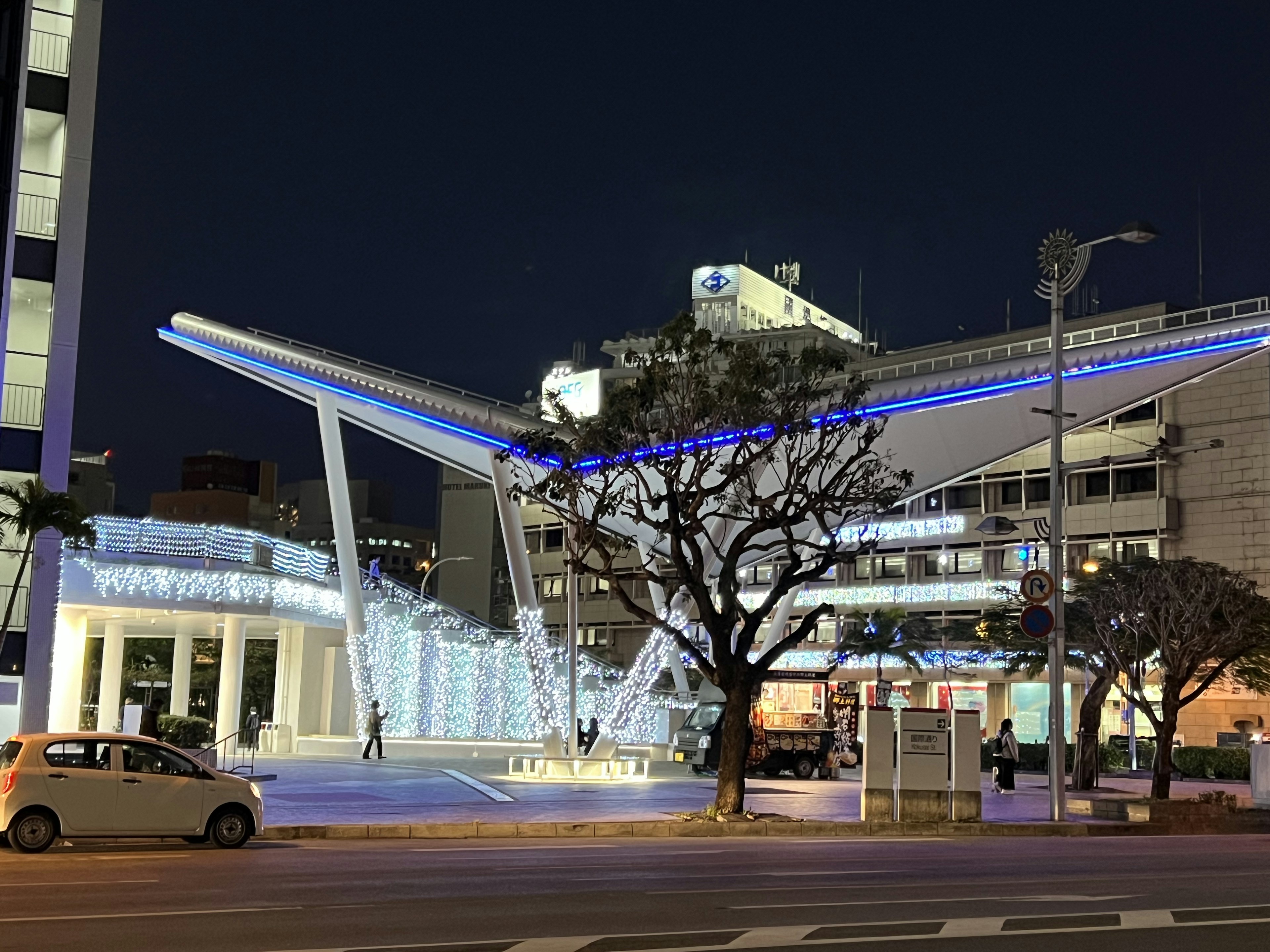 夜の街並みの中で輝く現代的な建物と青い照明