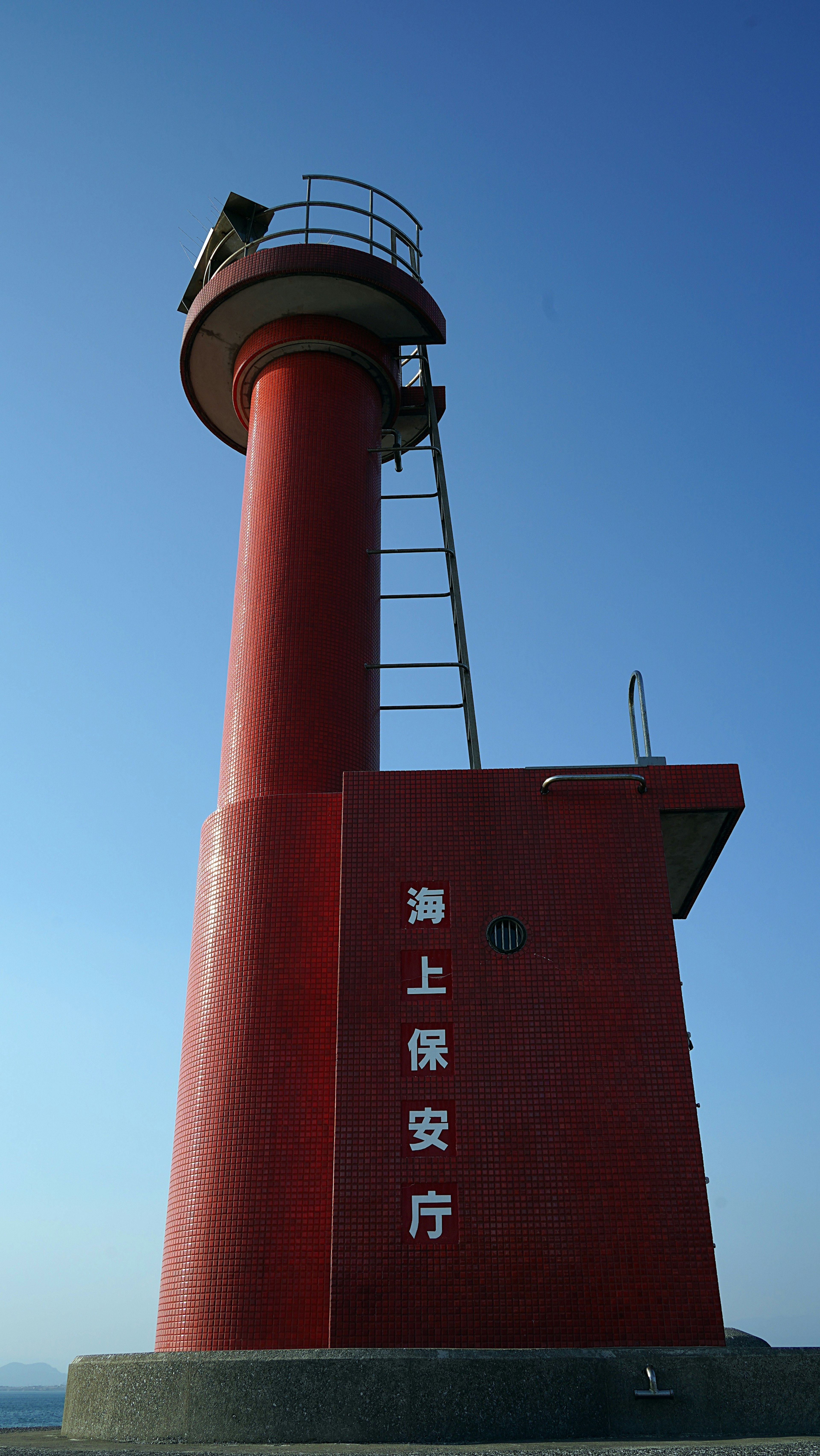 Faro rosso contro un cielo blu chiaro