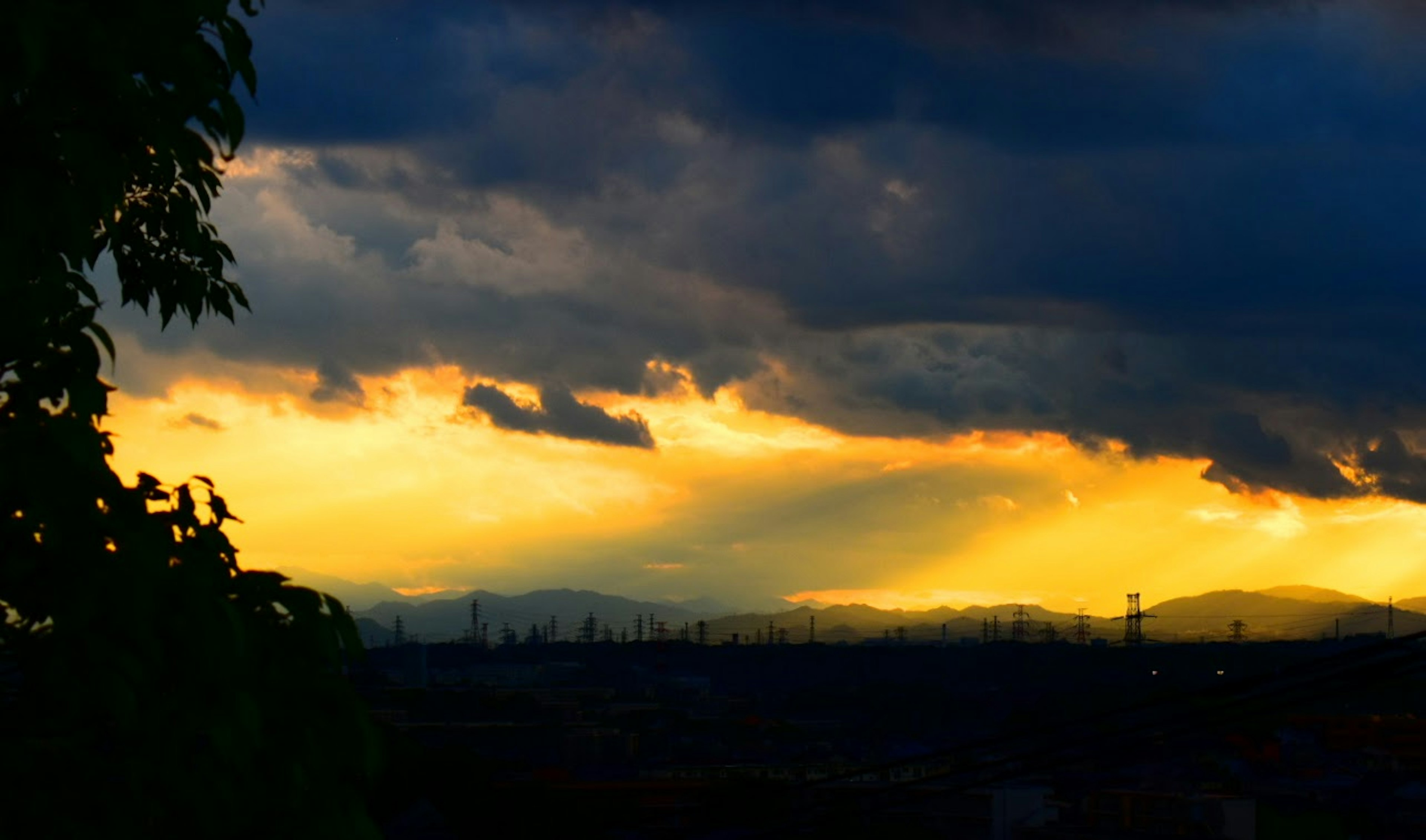 Coucher de soleil dramatique avec des nuages et des silhouettes de montagnes