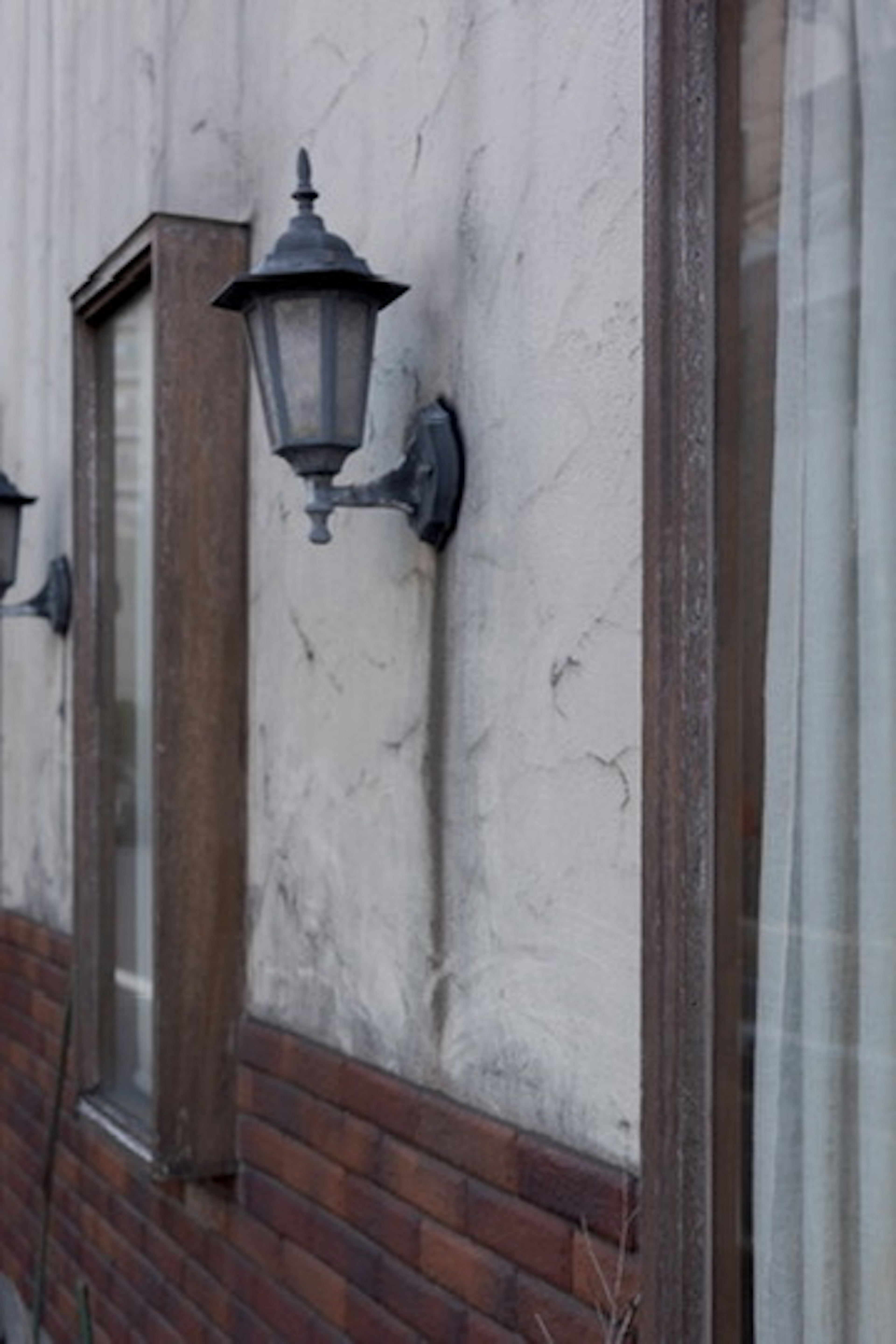 Vintage Laterne an einer strukturierten Wand mit Holzfensterrahmen montiert