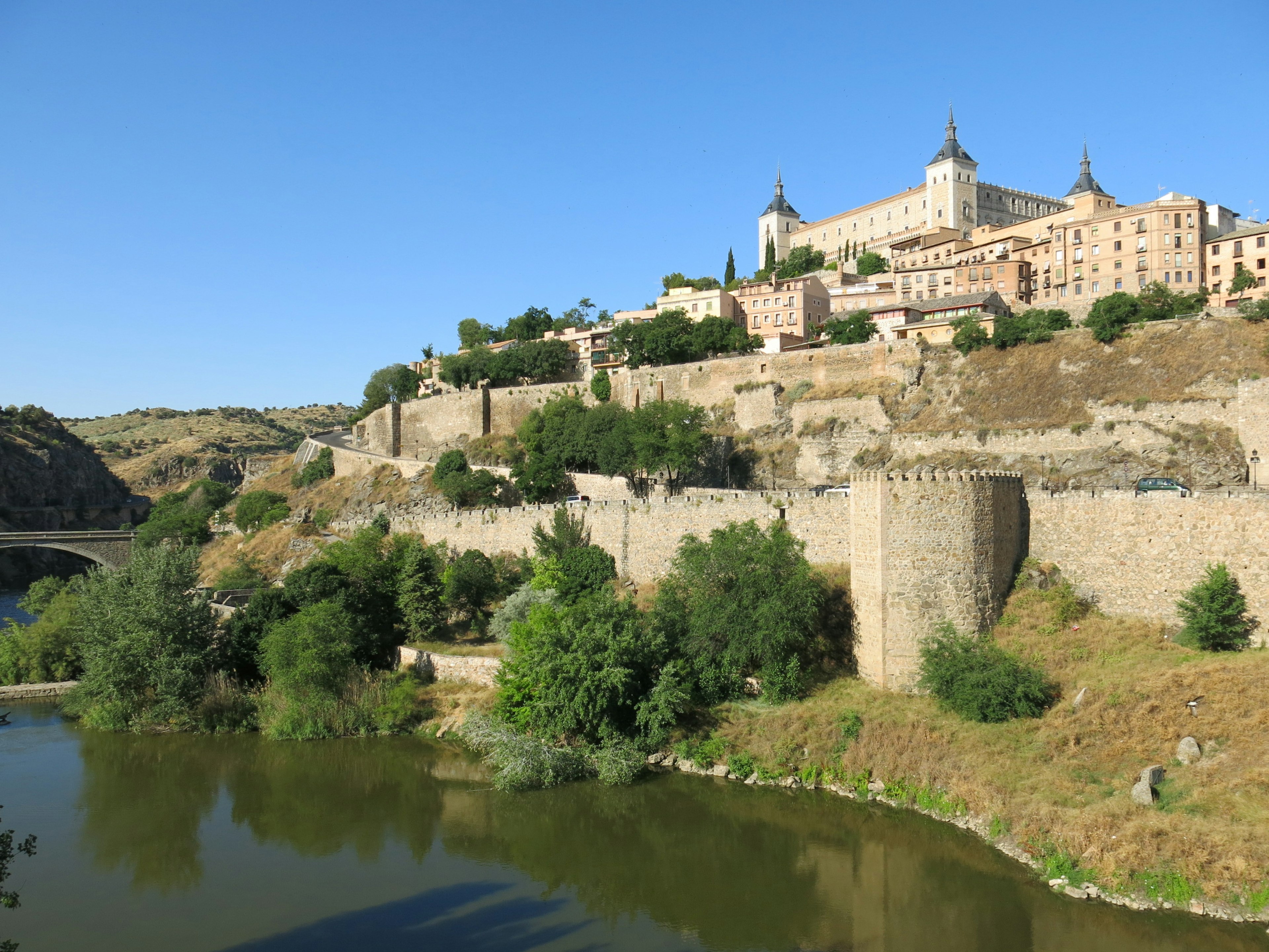 Vista panoramica delle mura storiche di Toledo e dell'Alcázar sotto un cielo sereno