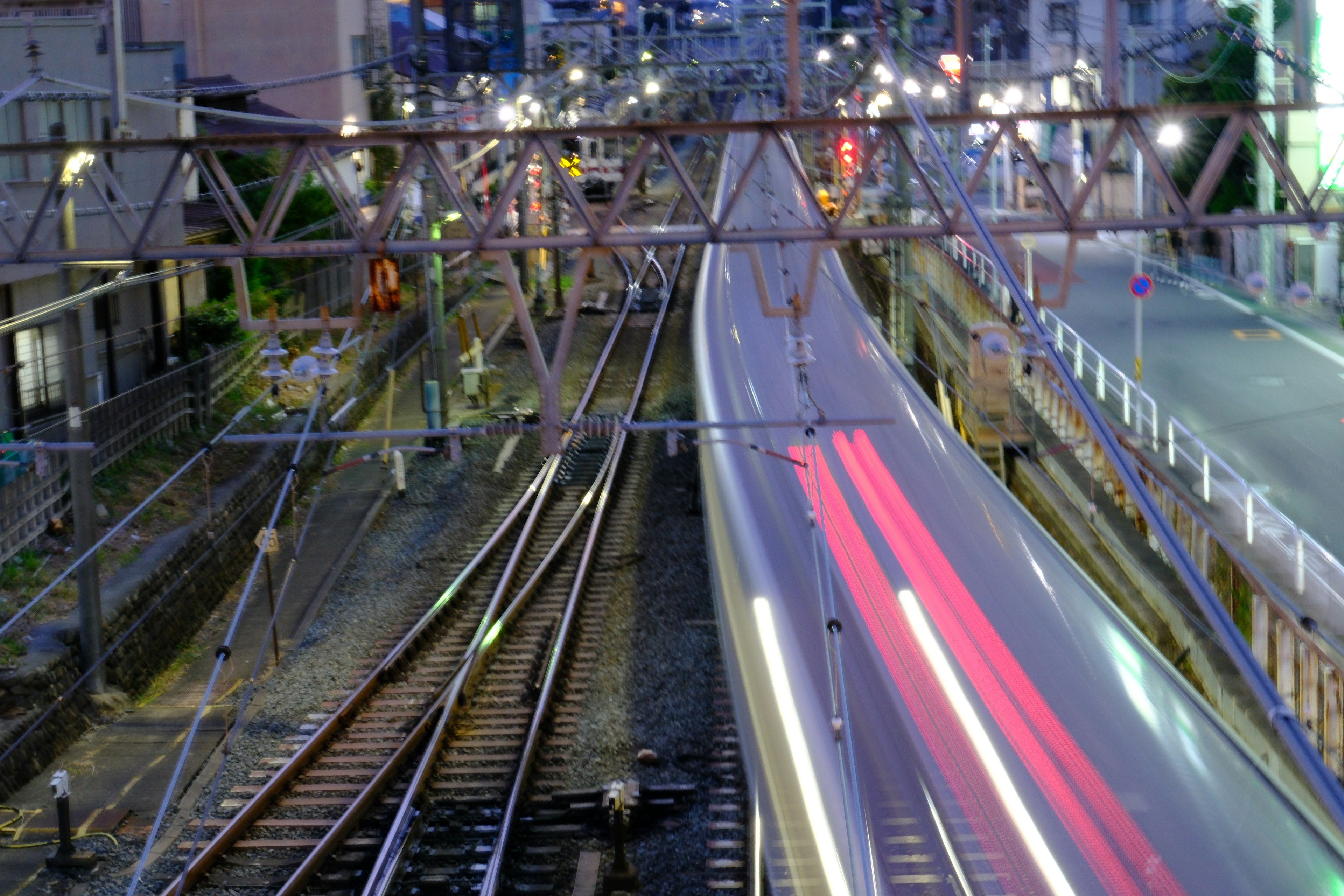 夜の都市における鉄道と道路の交差点の風景