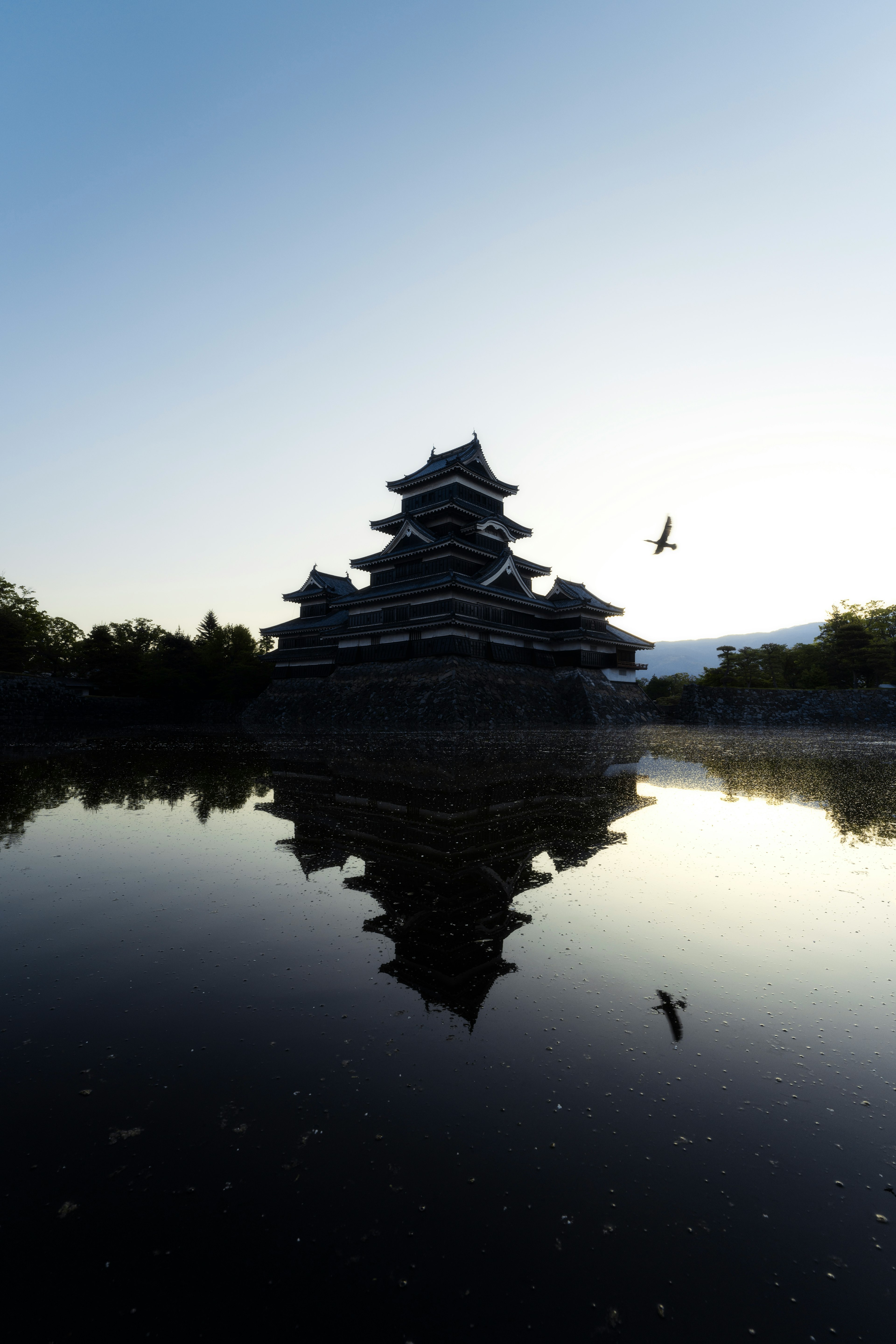 Silhouette von Matsumoto Castle im ruhigen Wasser reflektiert