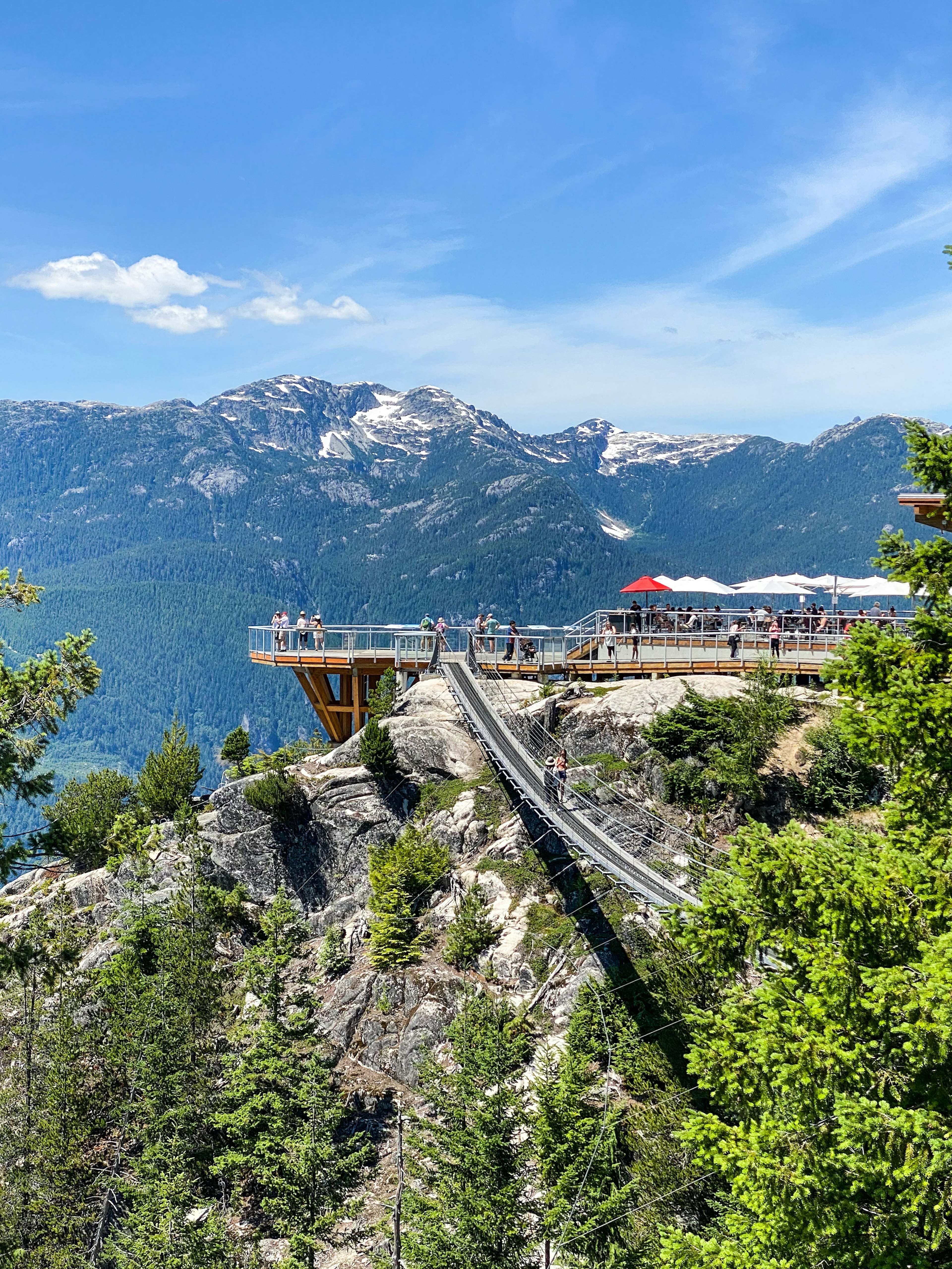 Mirador con pasarela de madera con vistas a montañas y lago