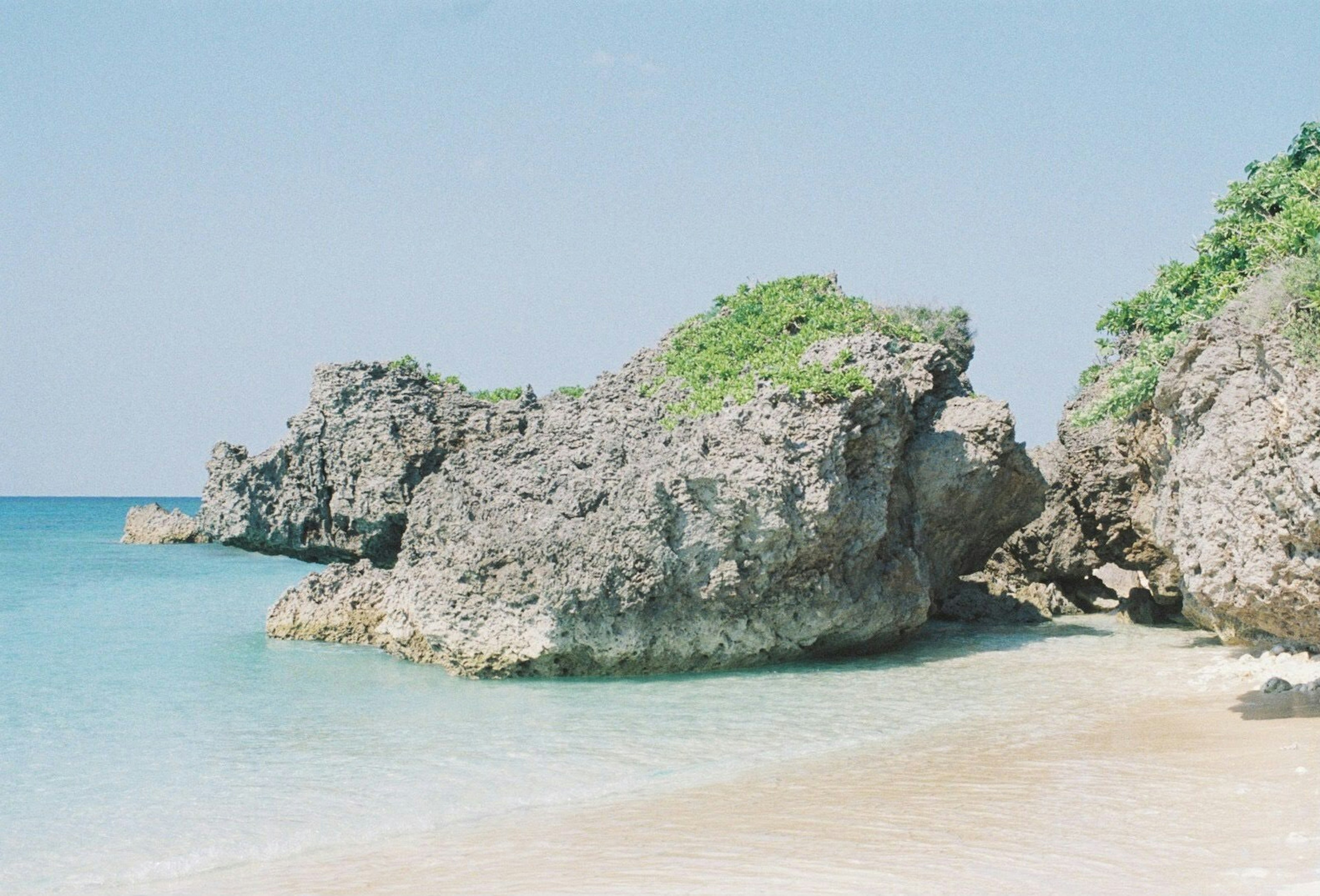 Scena di spiaggia con acqua blu e formazioni rocciose