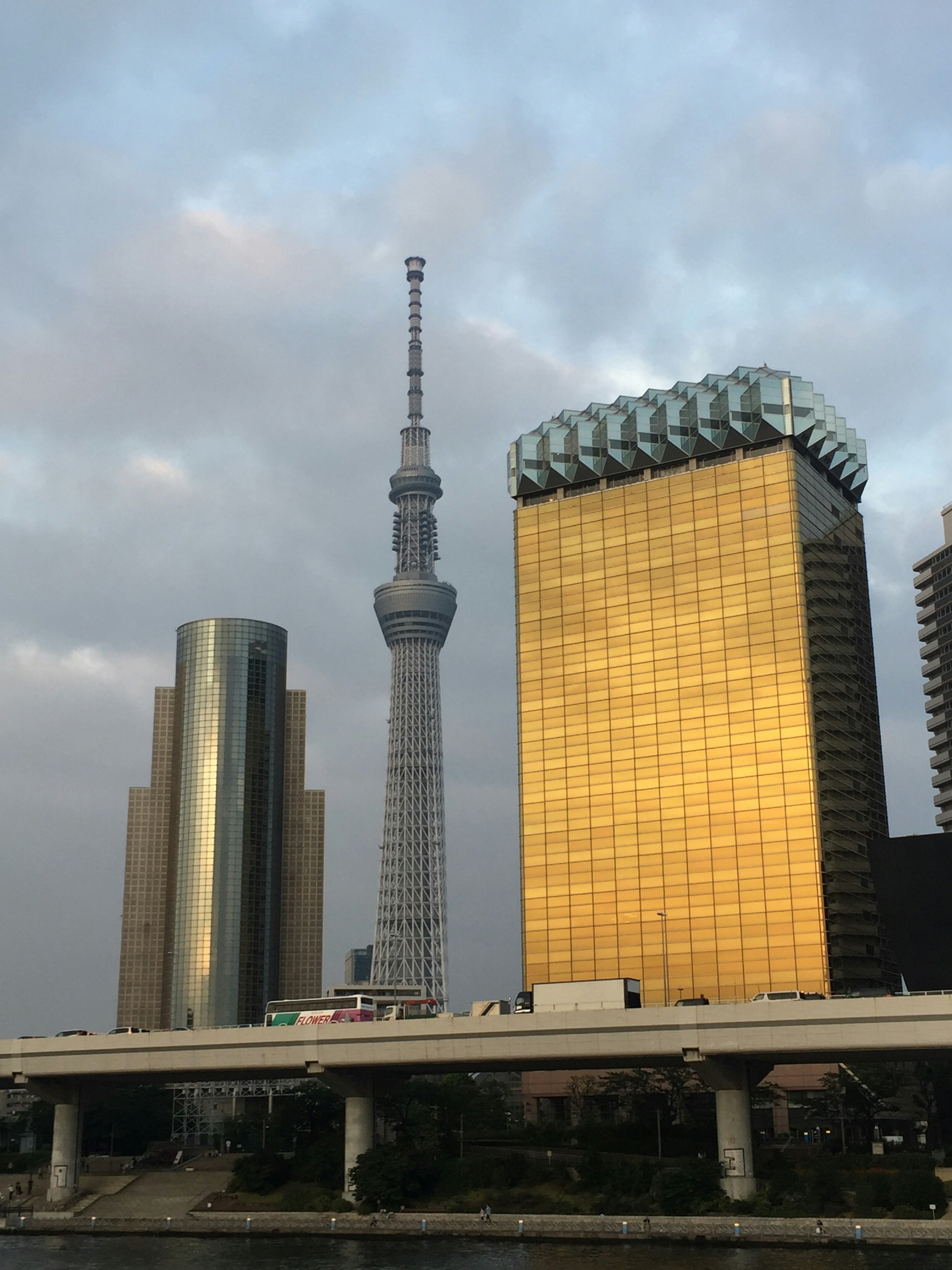 Tokyo Skytree junto a un edificio dorado bajo un cielo nublado