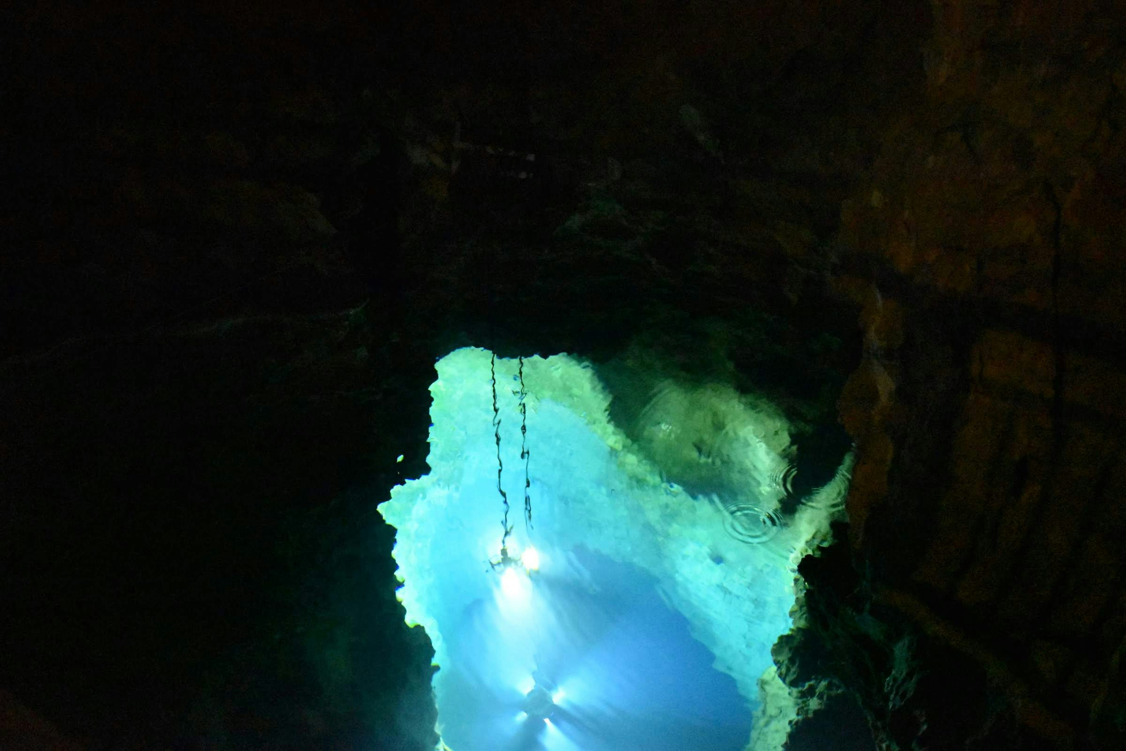 Underground water area with blue light reflections and rocky formations