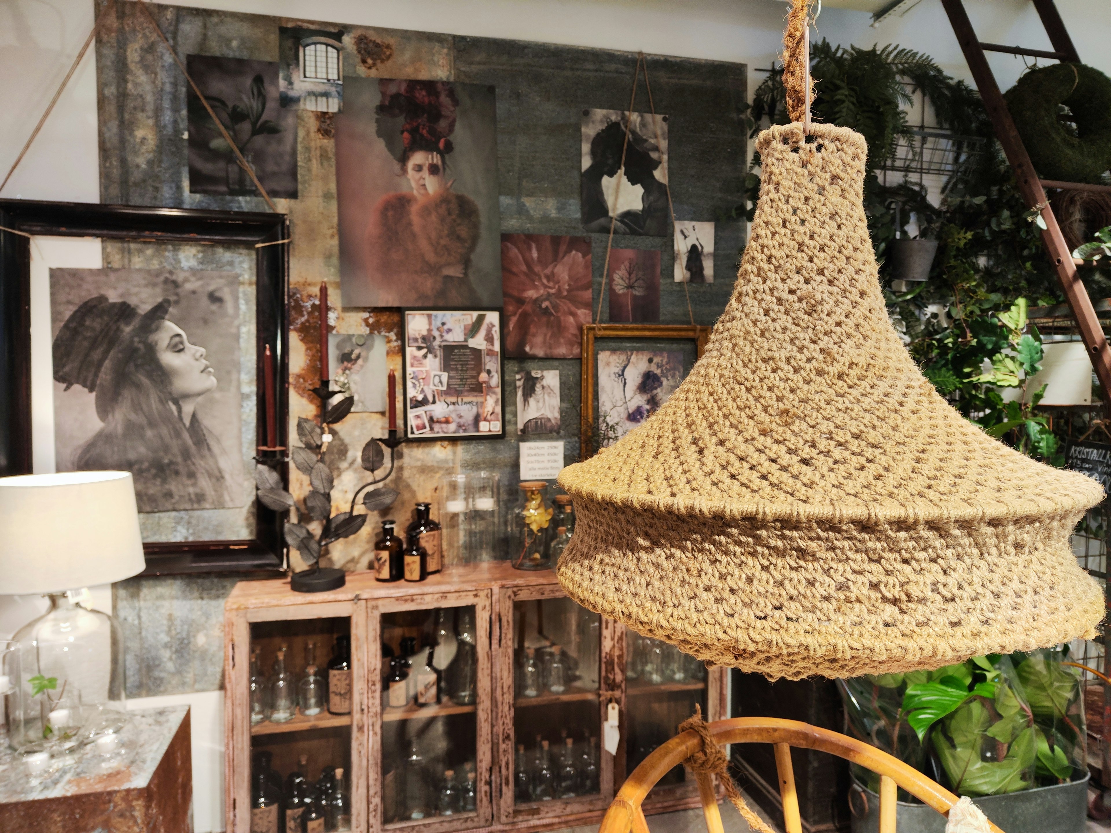 Interior space featuring woven lighting fixture surrounded by art and plants