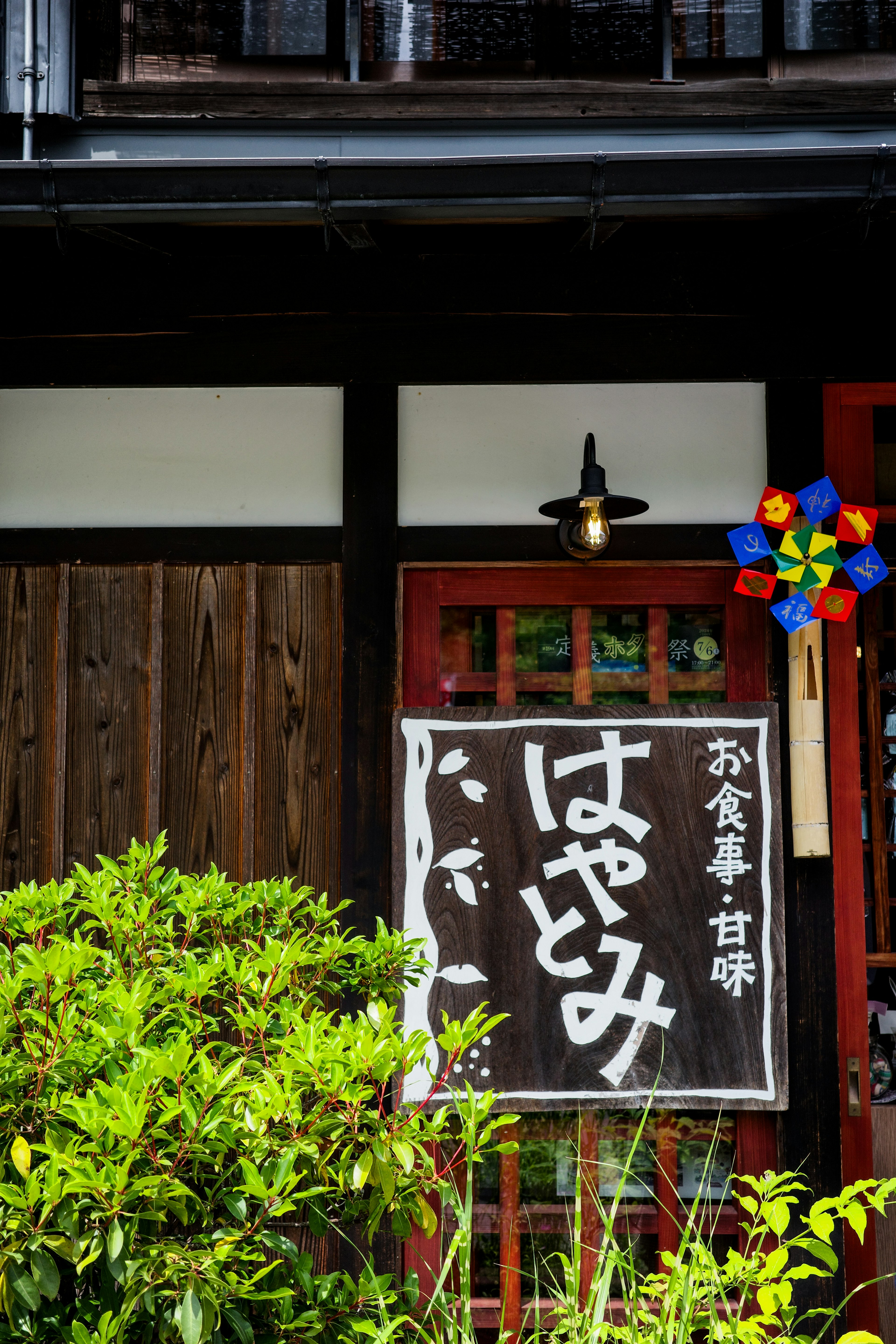 传统日本餐馆外观，标志为'はやみ'，周围绿植繁茂