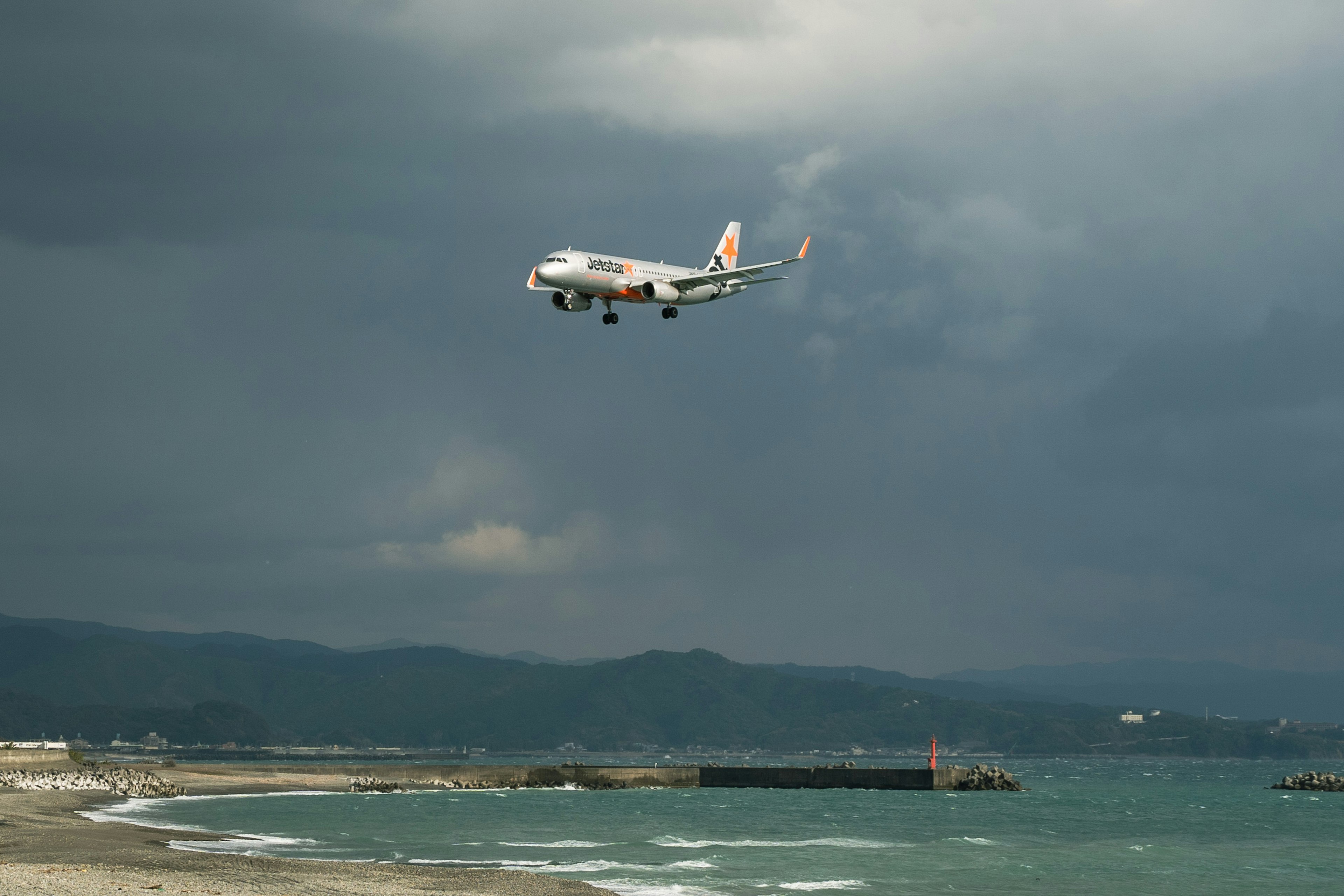 空港に近づく飛行機と暗い雲の背景