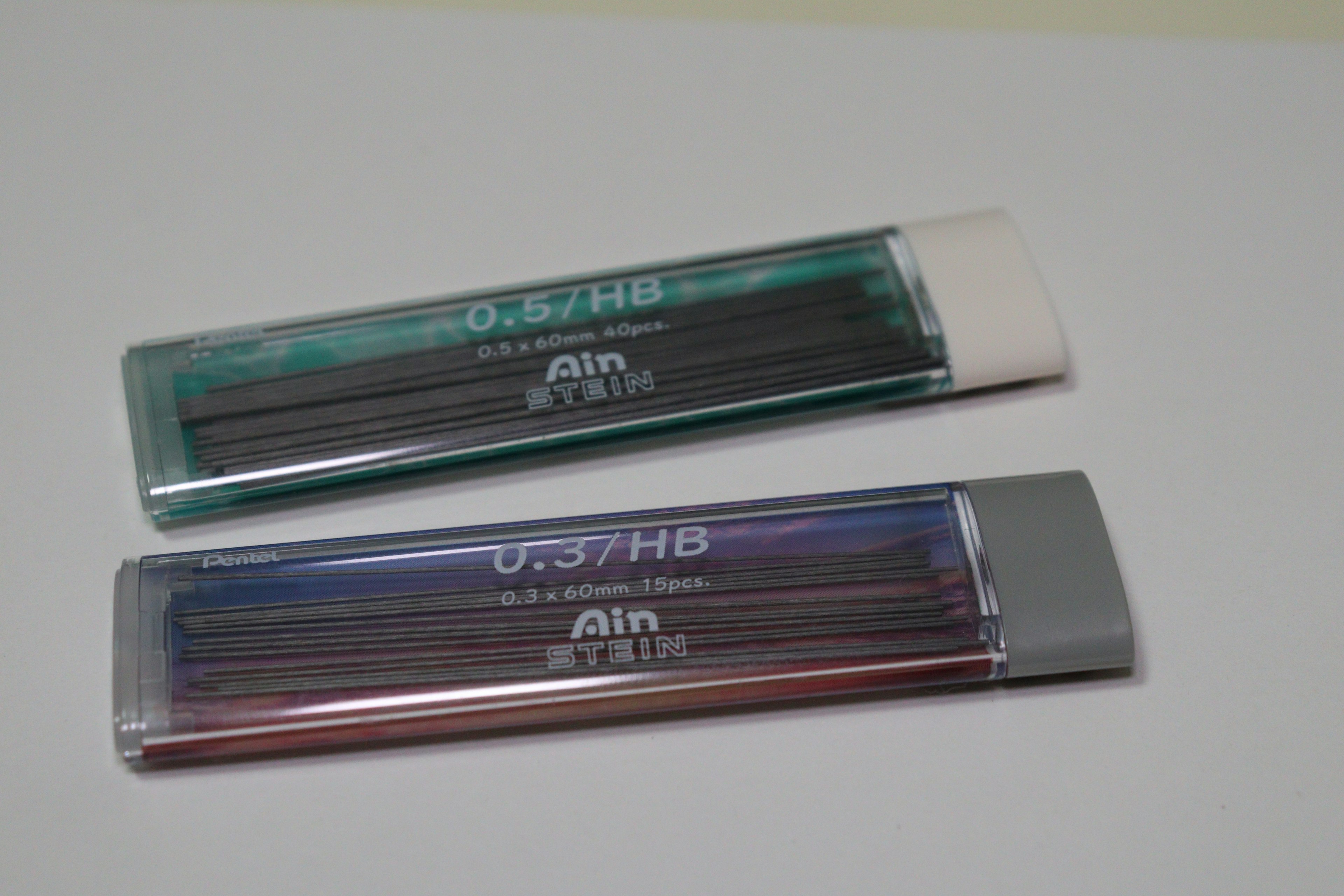 Set of pencils in green and blue transparent cases and purple case