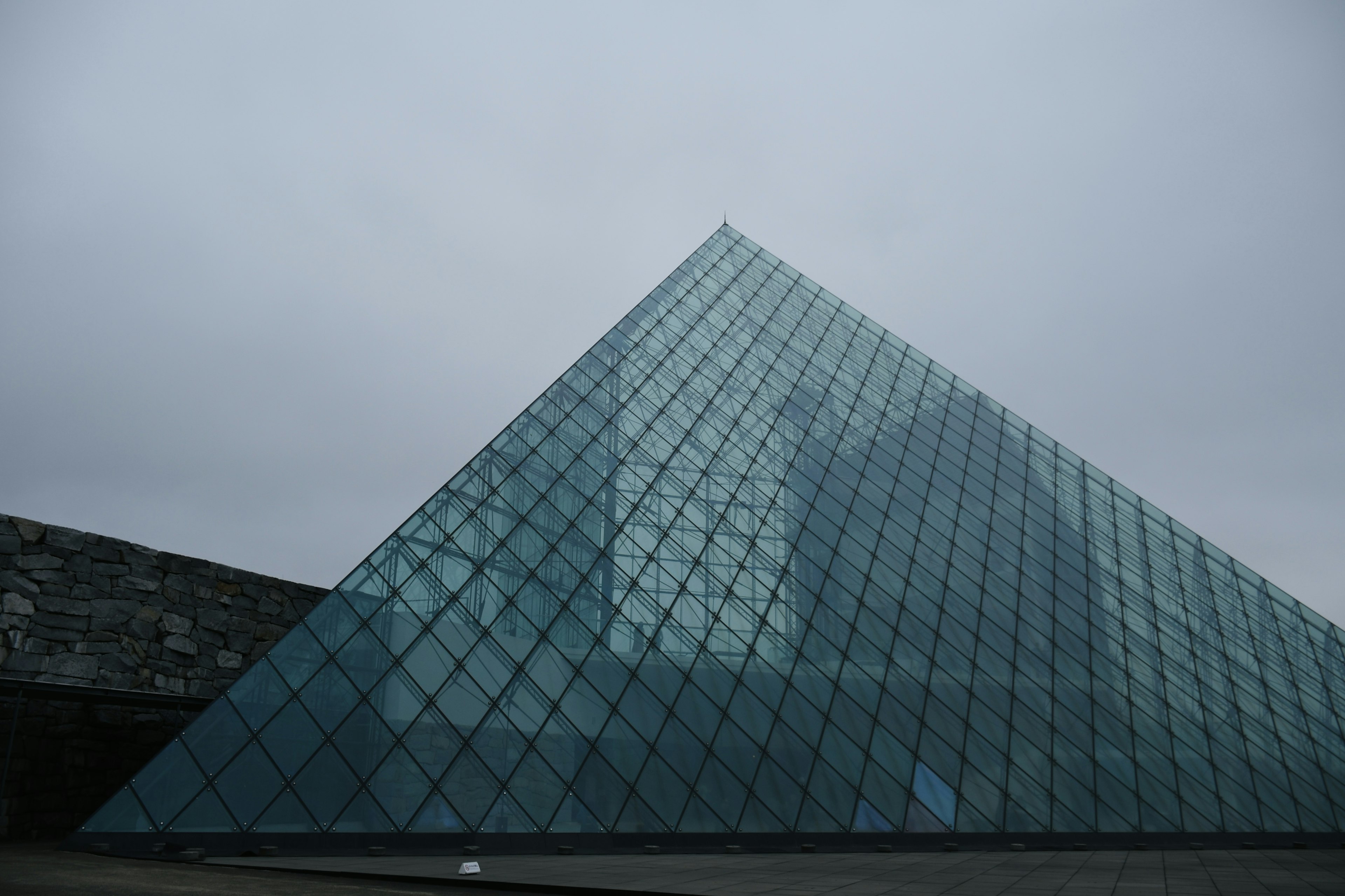 Glass pyramid with overcast sky