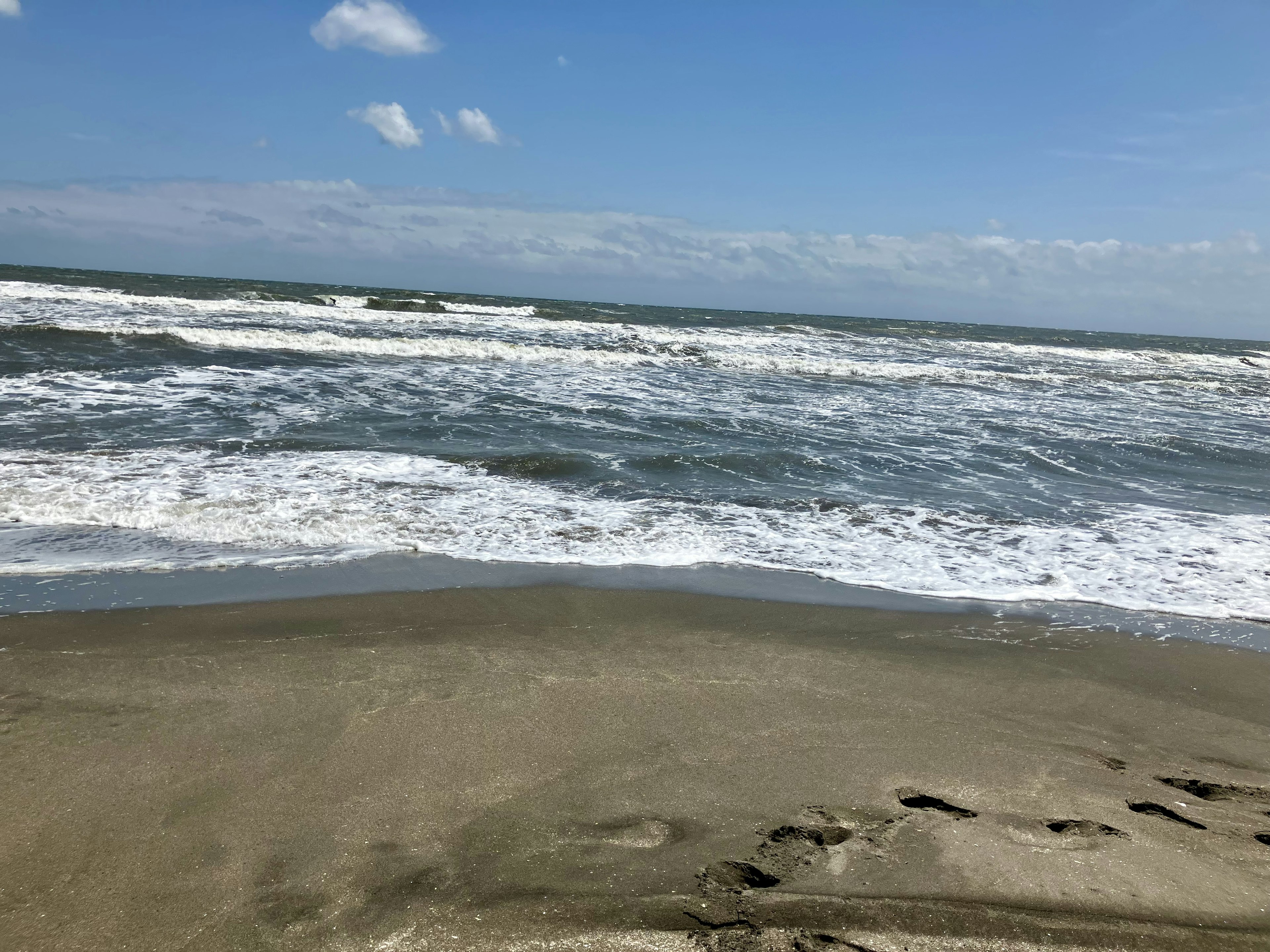 Vista de una playa de arena con olas rompiendo