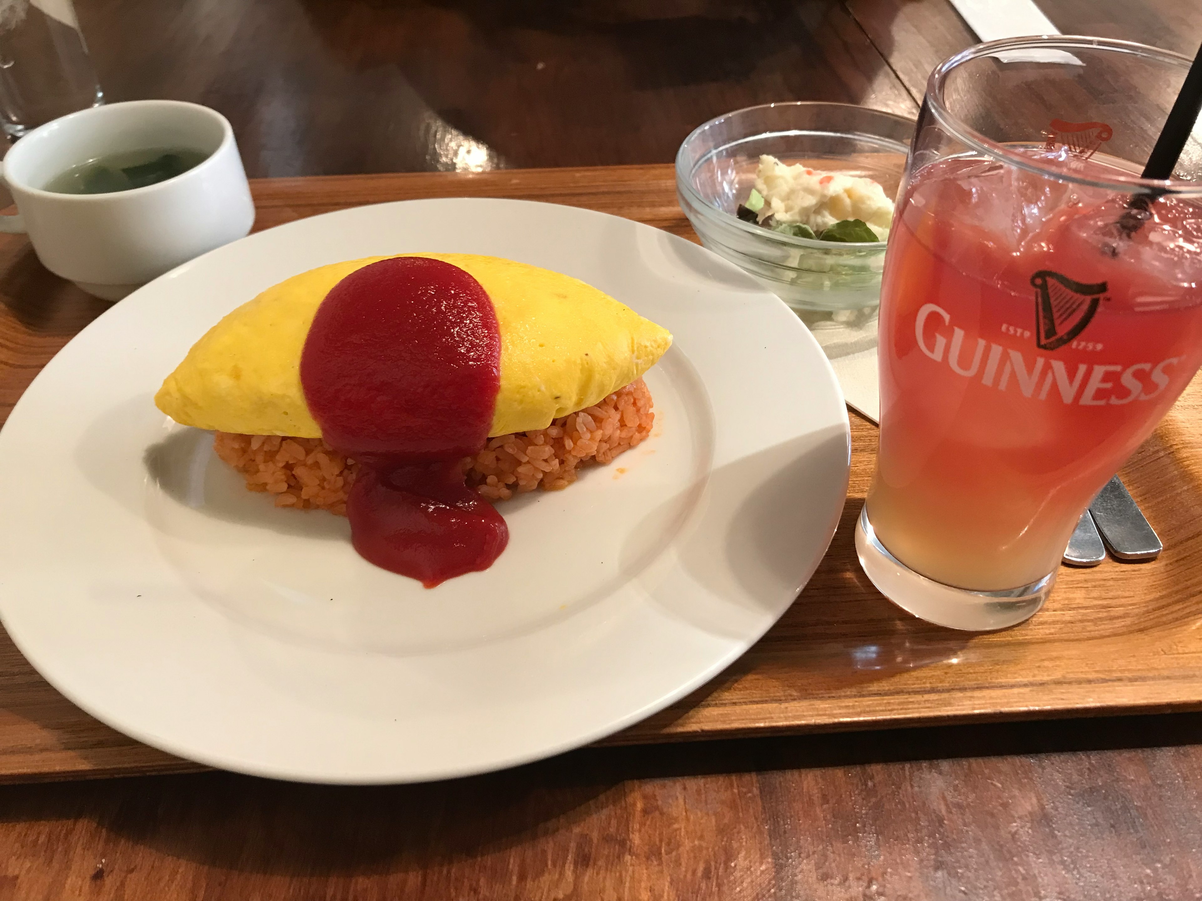 Đĩa omurice với sốt cà chua và một ly cocktail