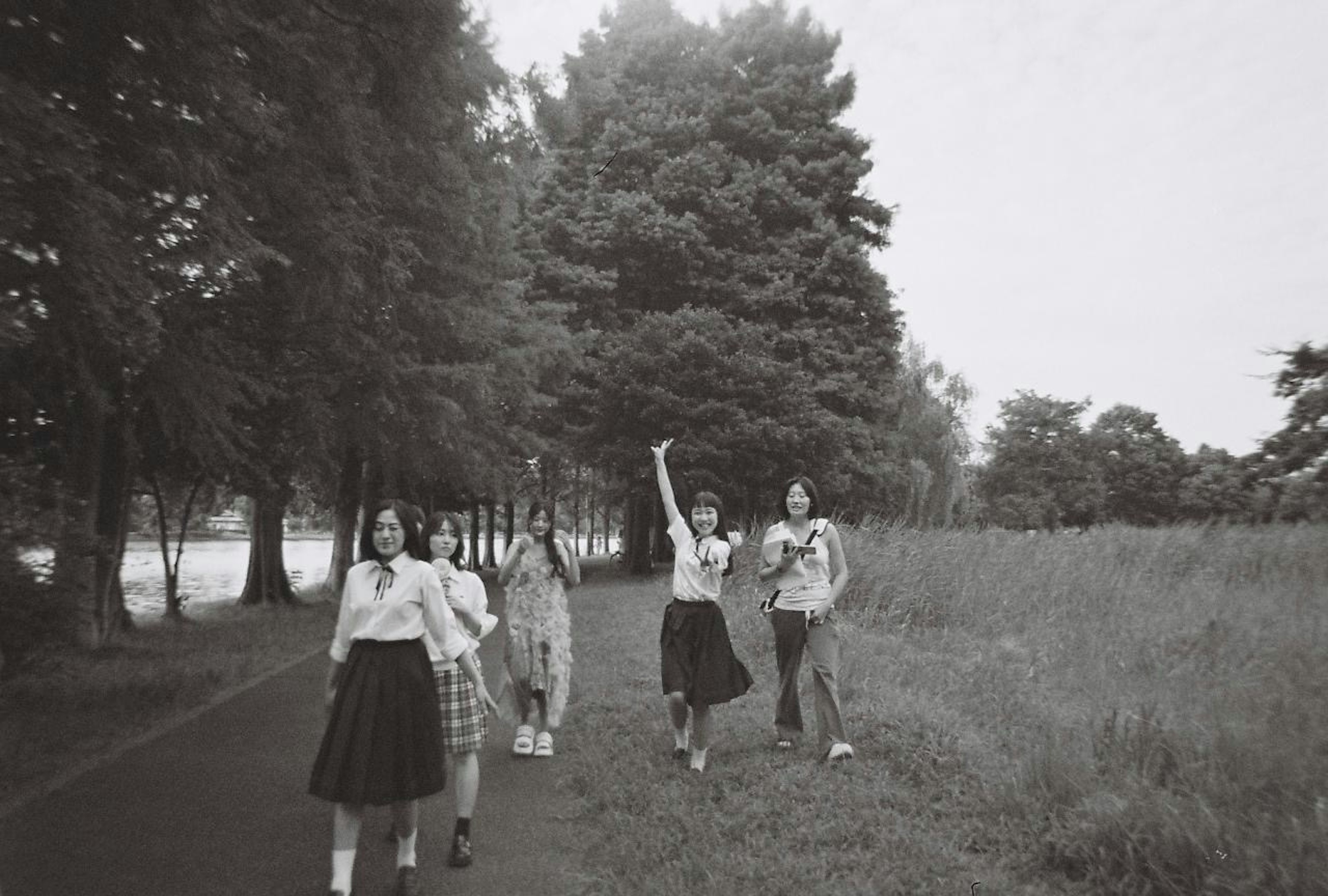 Black and white photo of five women walking along a path