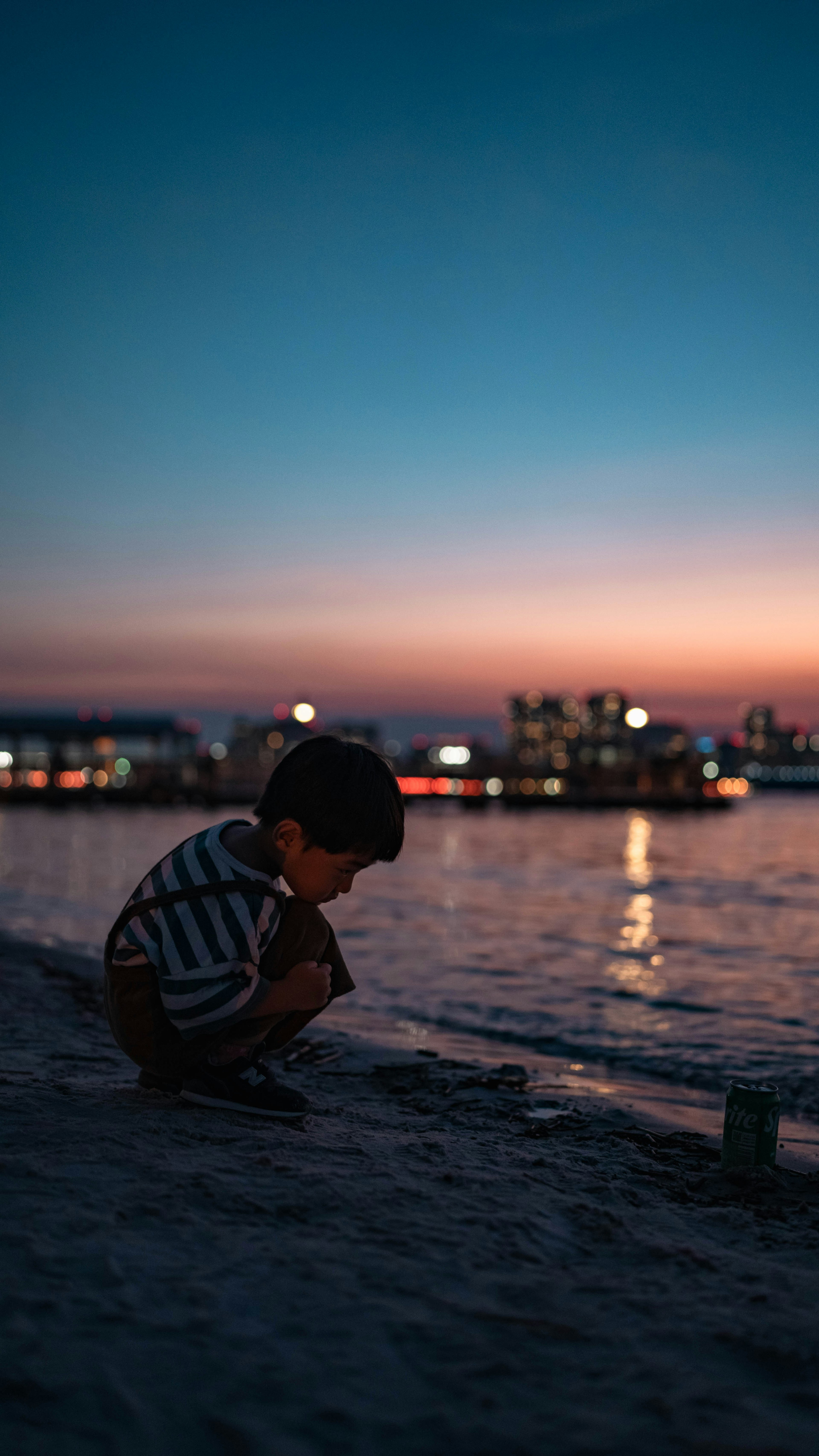 夕暮れの海辺で遊ぶ子供のシルエット