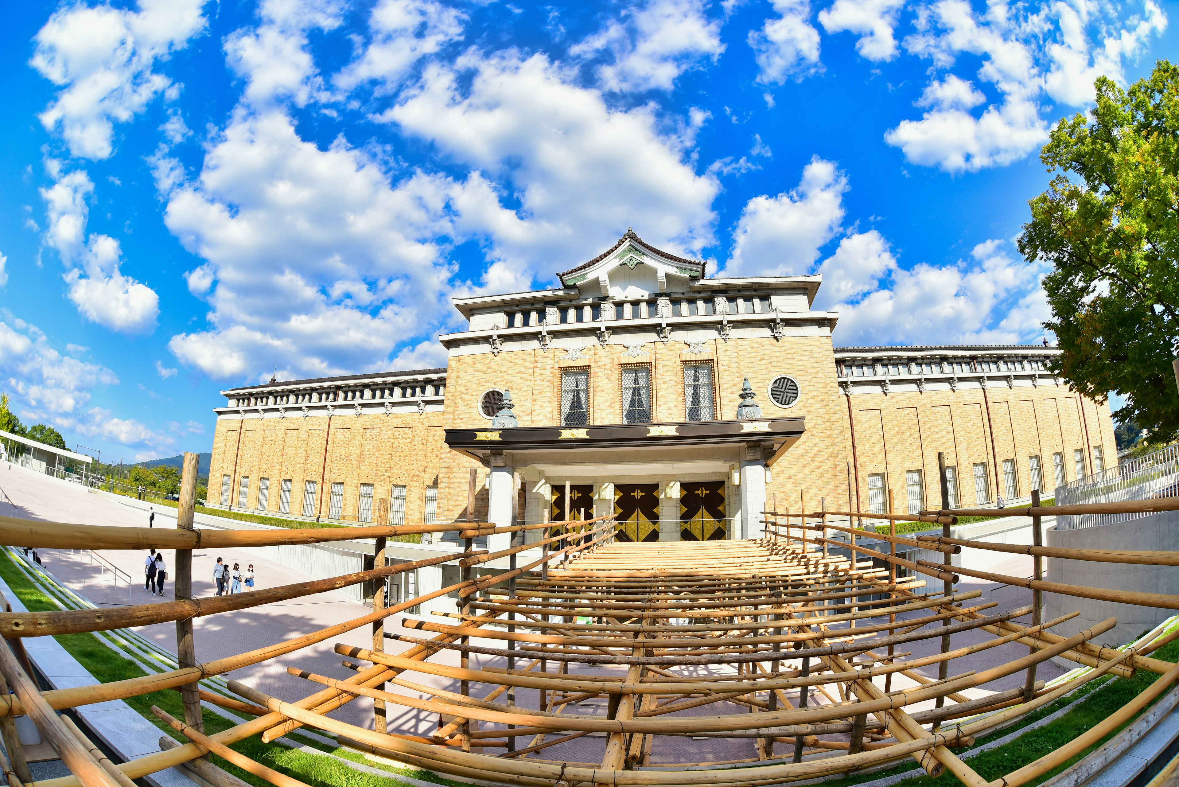 Eksterior museum seni modern di bawah langit biru dengan tempat duduk kayu