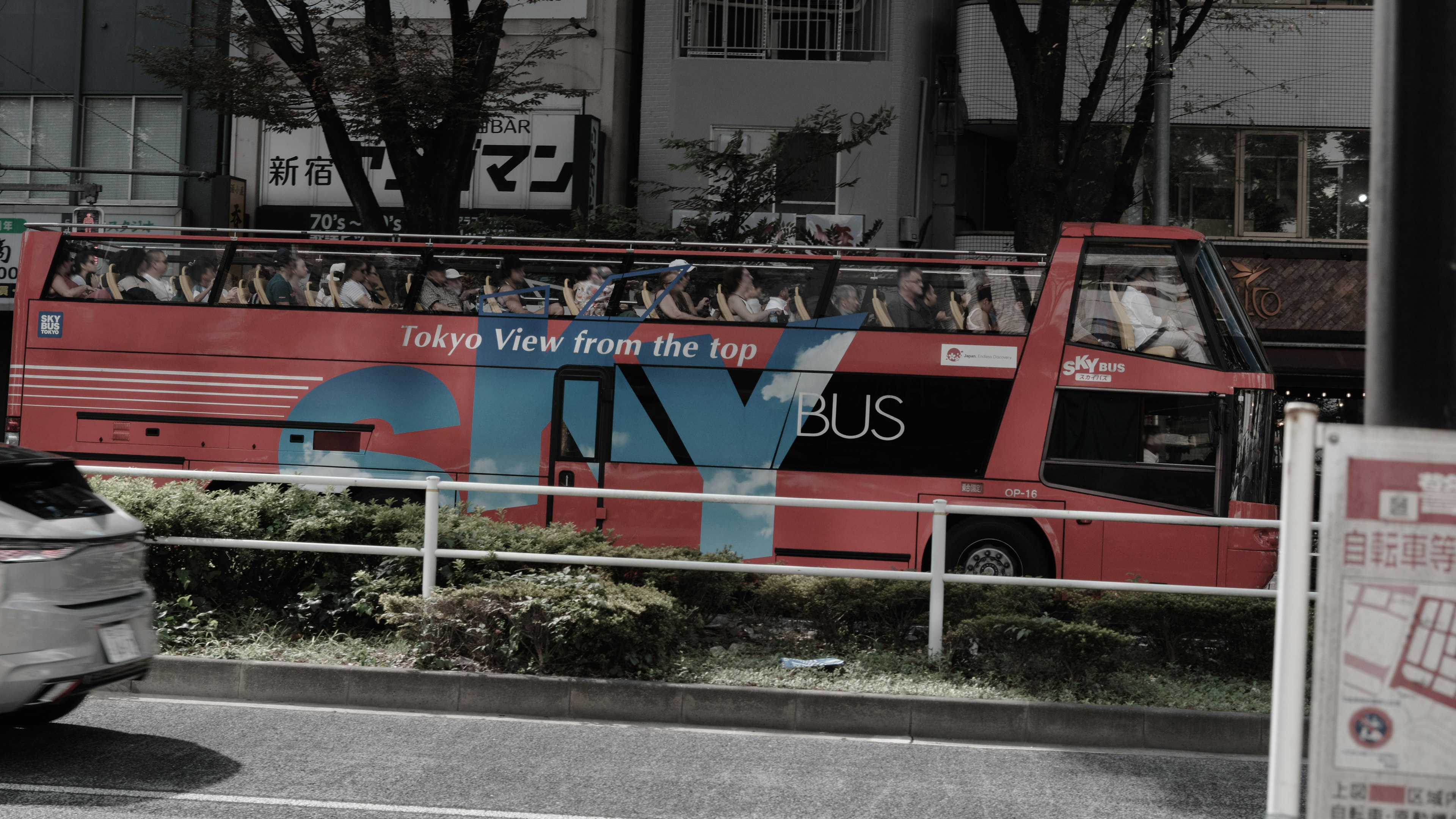 Red double-decker sightseeing bus parked in a cityscape