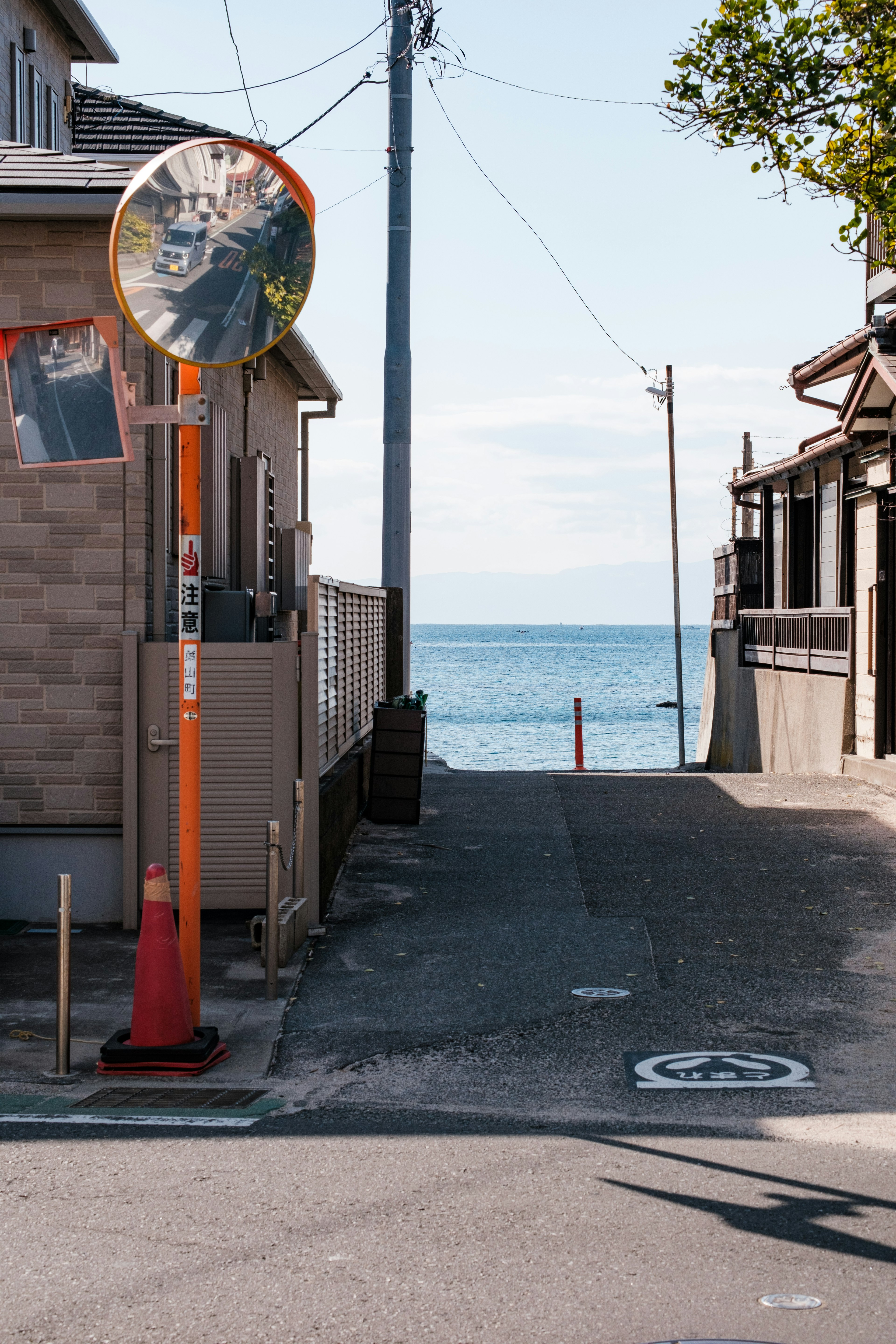 Street leading to the ocean with a mirror and houses