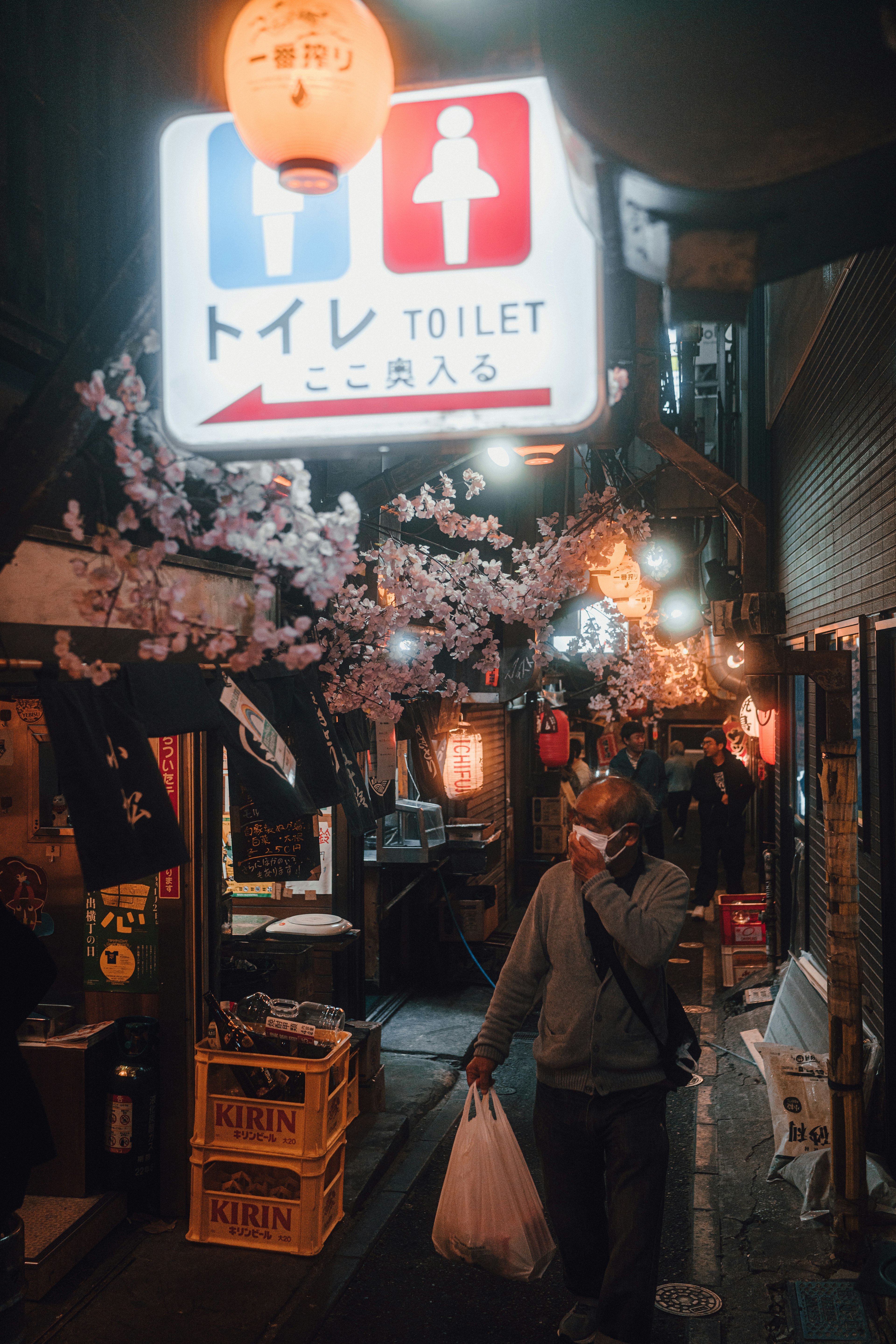 夜の街並みにあるトイレの看板と桜の装飾