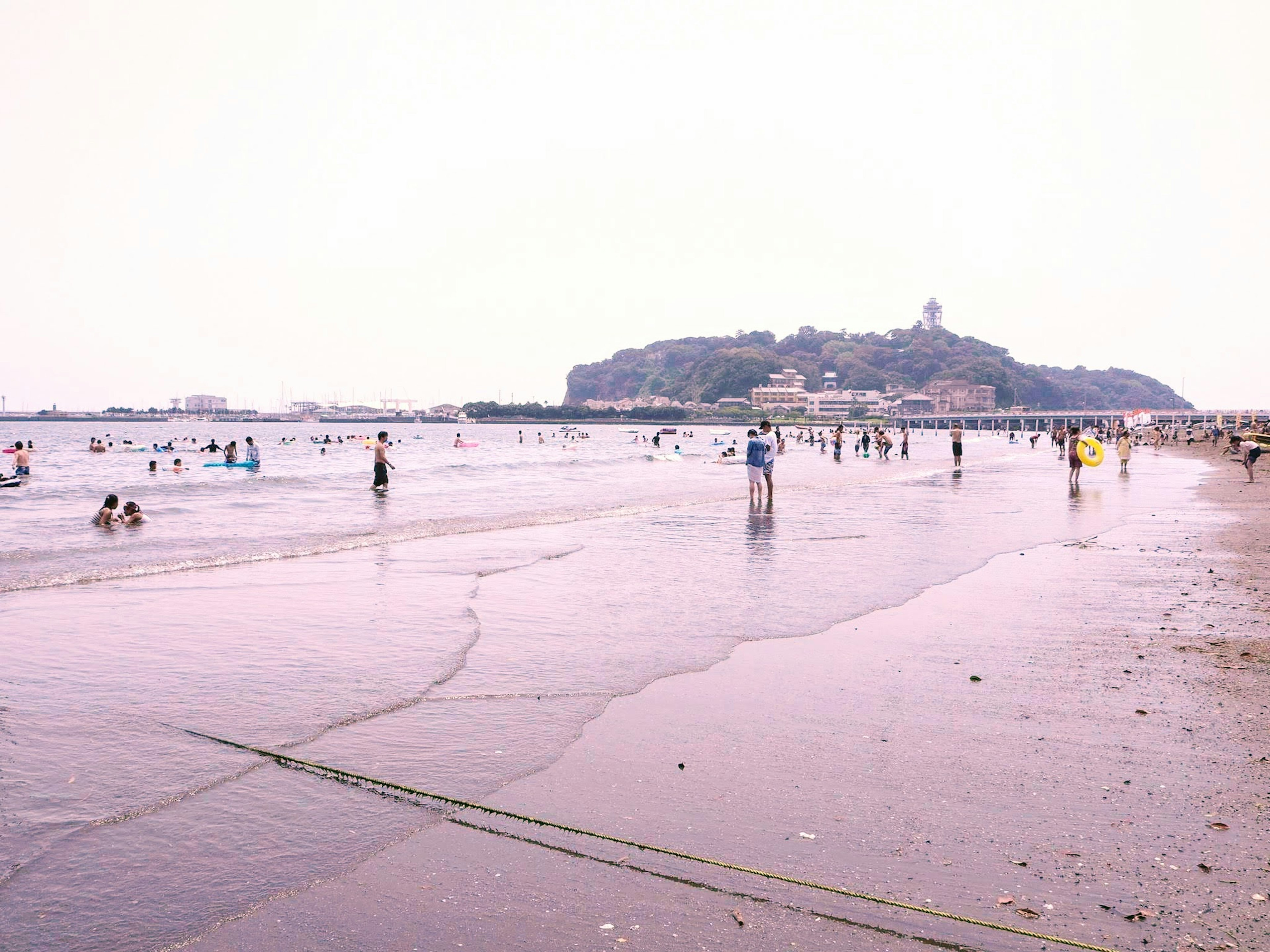 Personas disfrutando de la playa con vista a una colina lejana