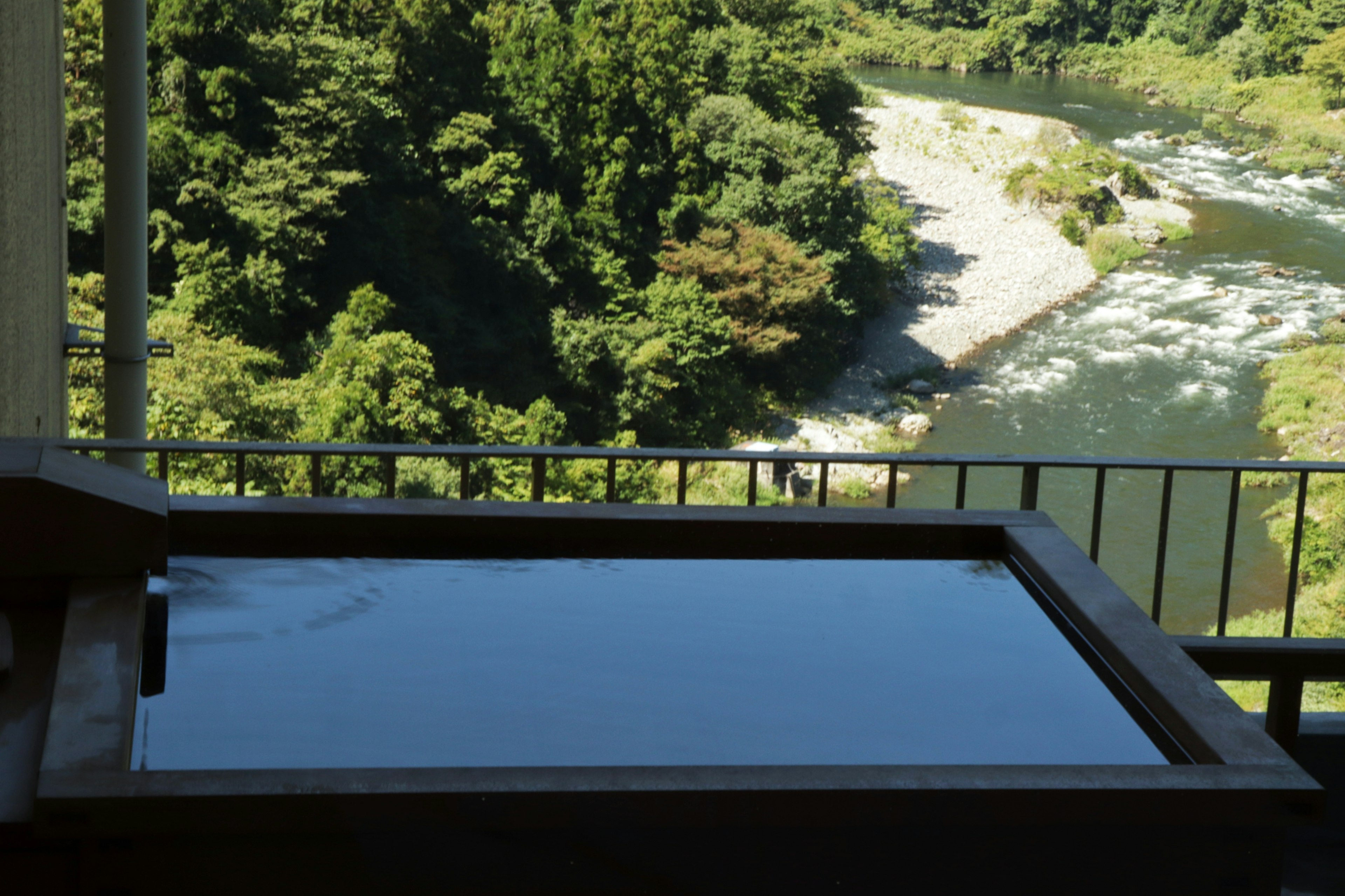 Wooden bathtub overlooking a beautiful river landscape