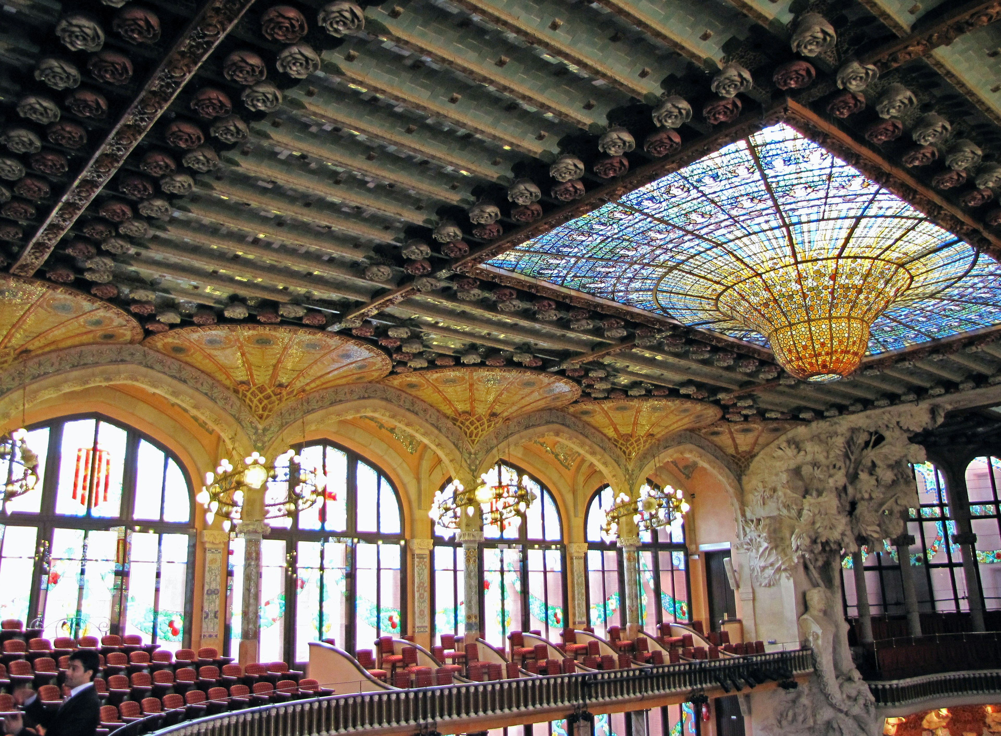 Interior of a concert hall in Barcelona featuring a stunning ceiling and stained glass lighting