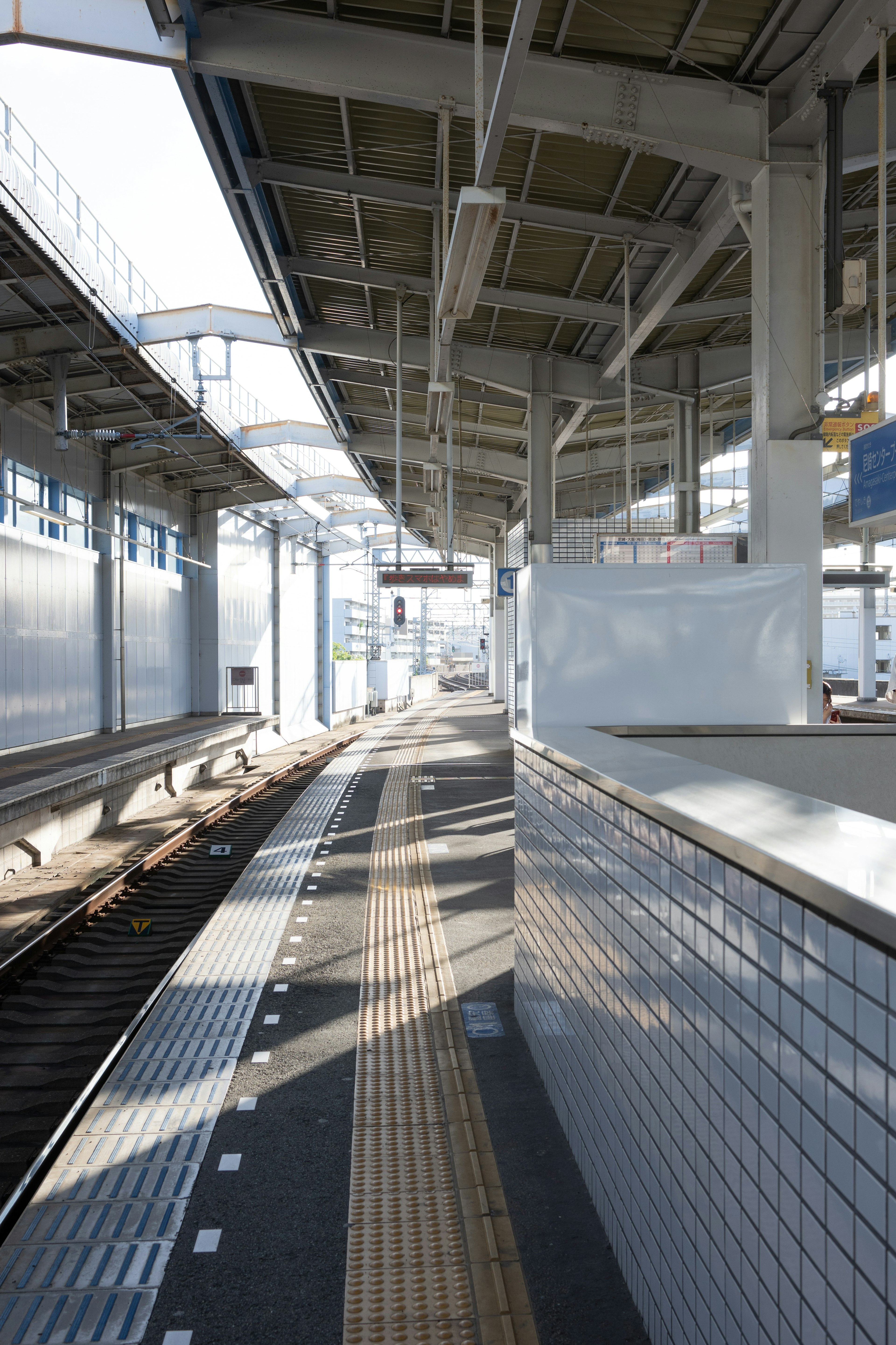 明るい駅のプラットフォーム 鉄道の線路と長い影