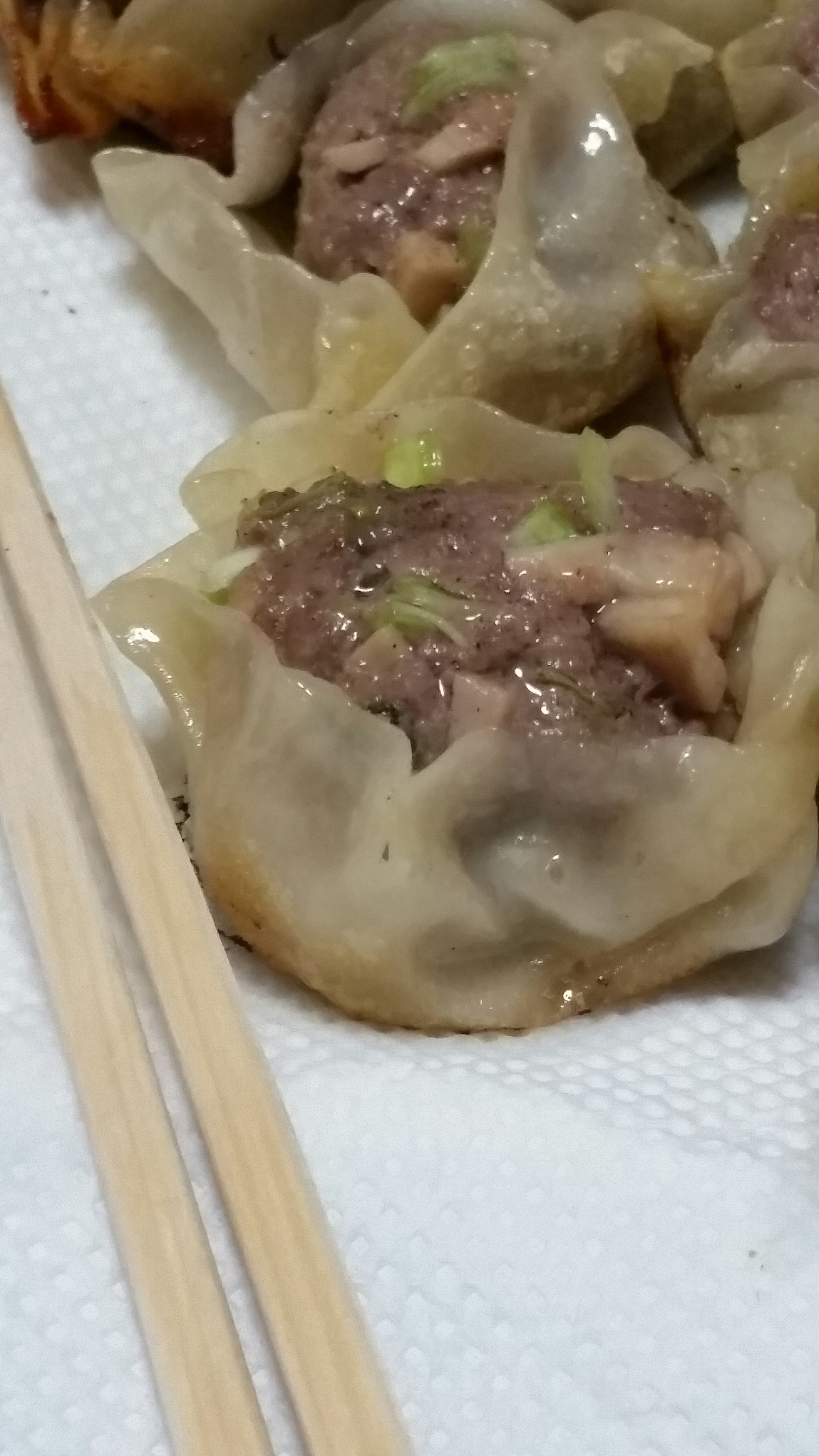 Close-up of meat dumplings on a plate with chopsticks