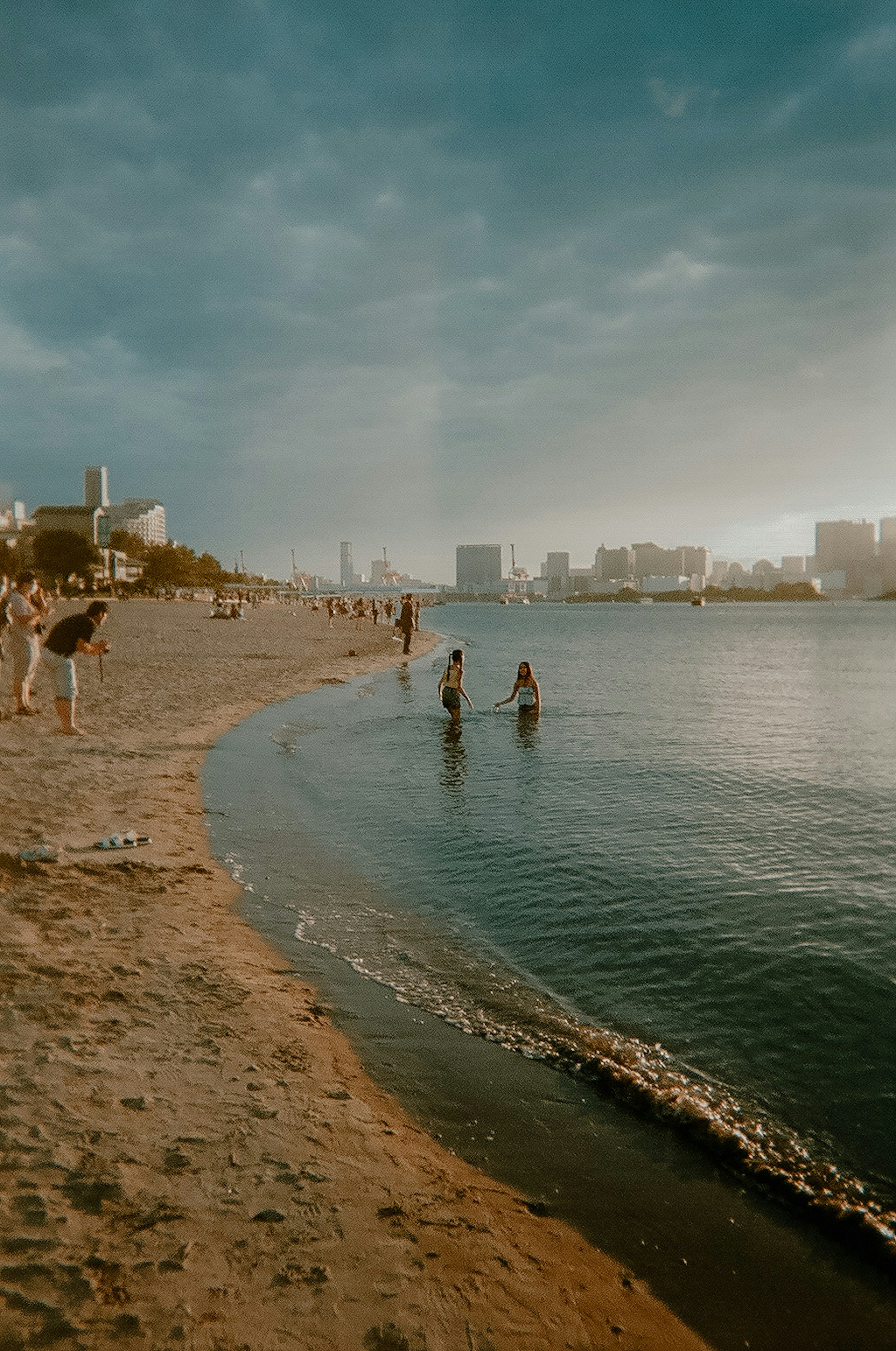 ビーチで遊ぶ人々と穏やかな水面の風景