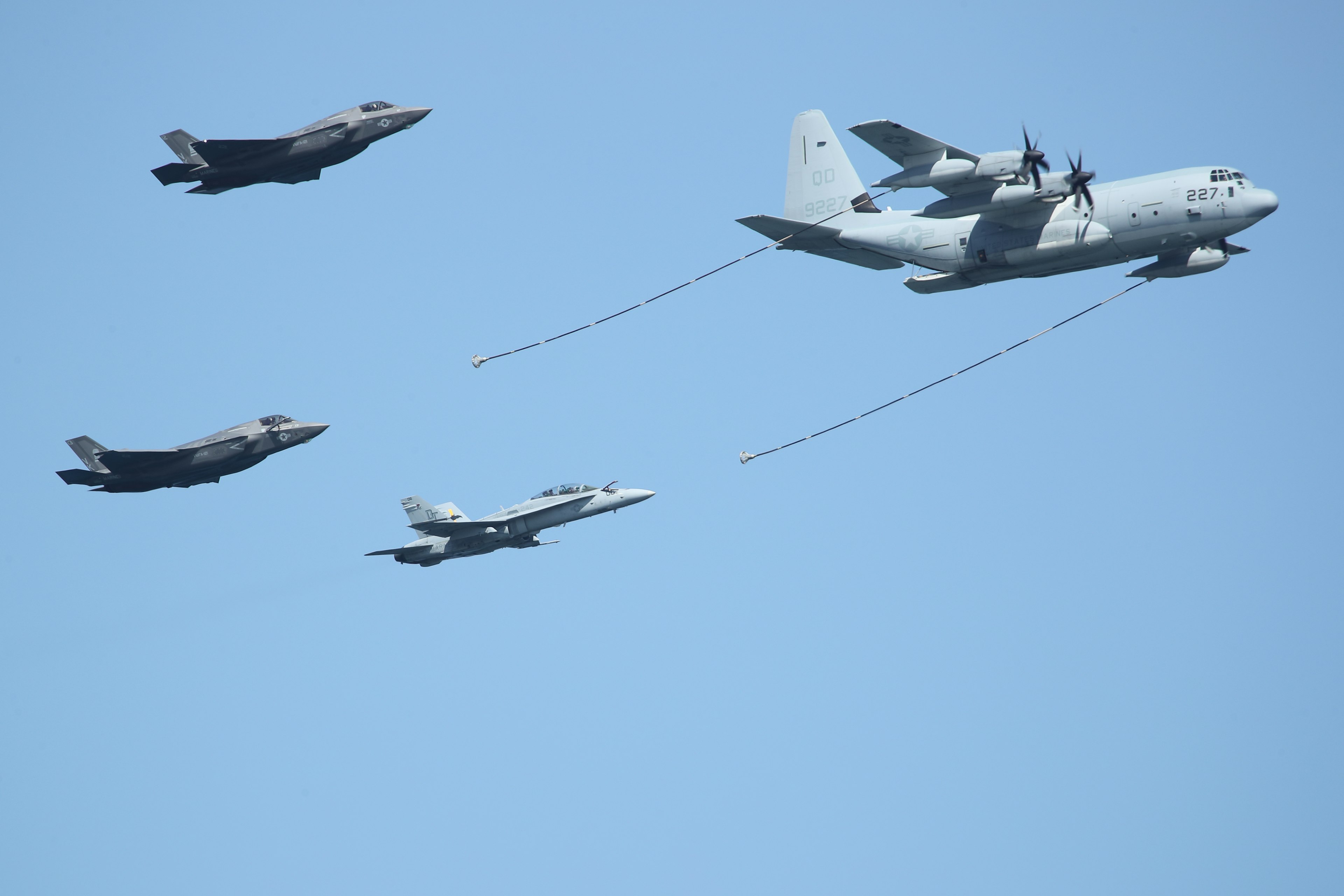 Four military aircraft flying in a clear blue sky