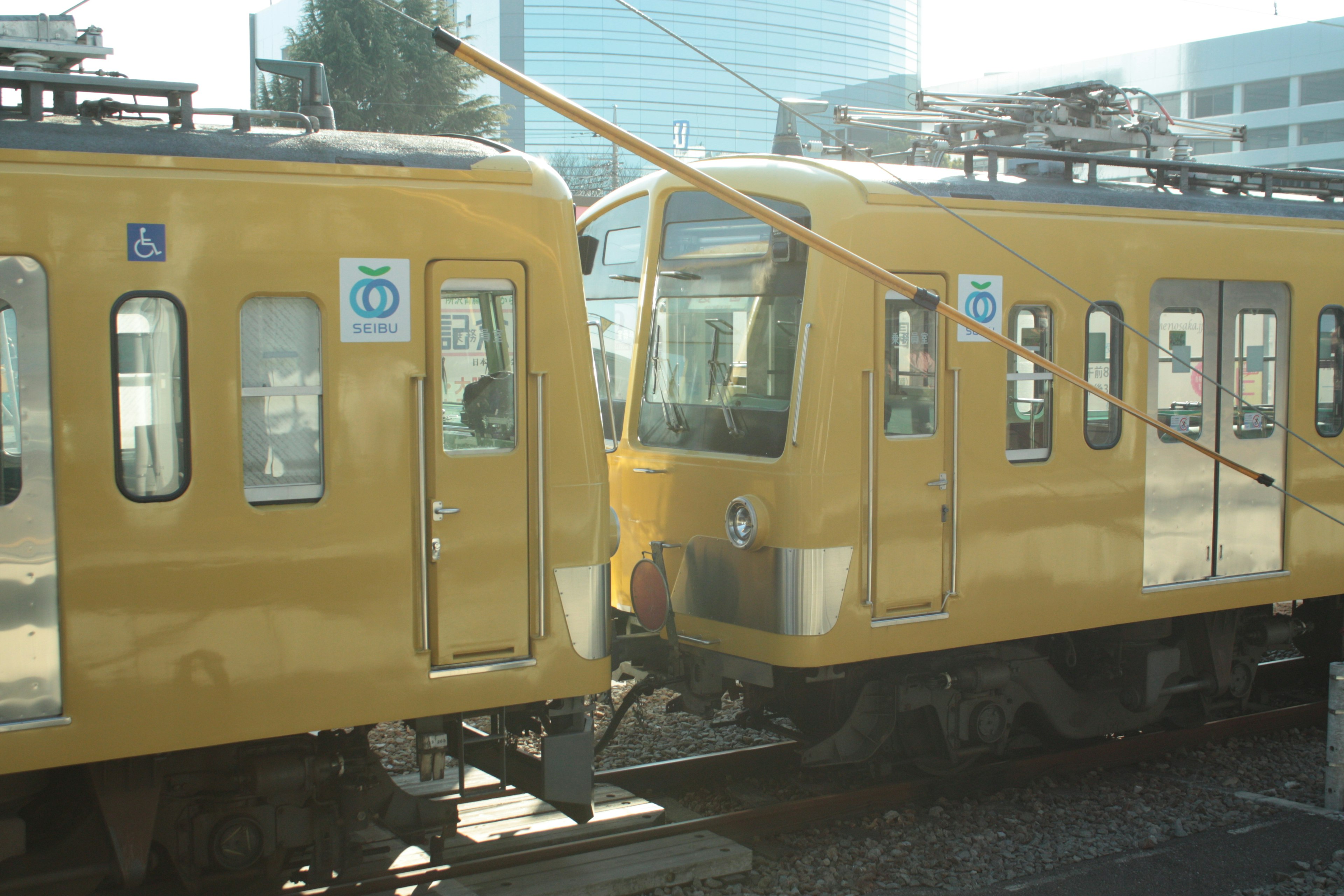 Two yellow trains intersecting at a station