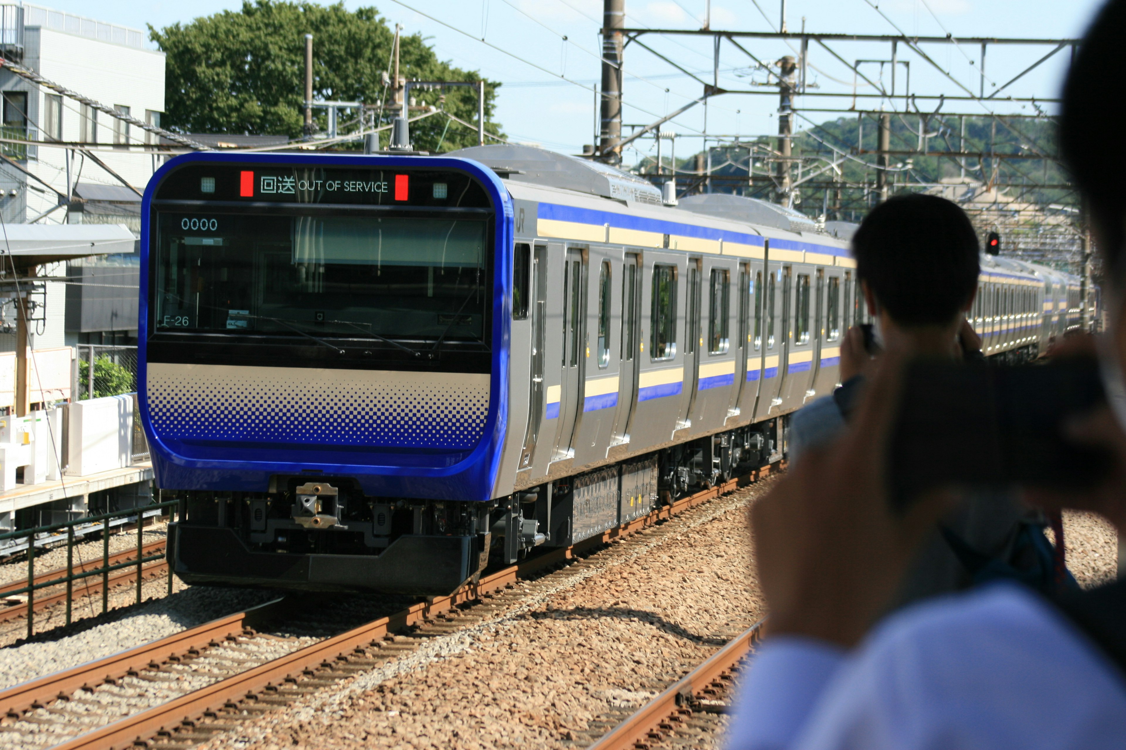 青い電車が線路を走る駅の風景