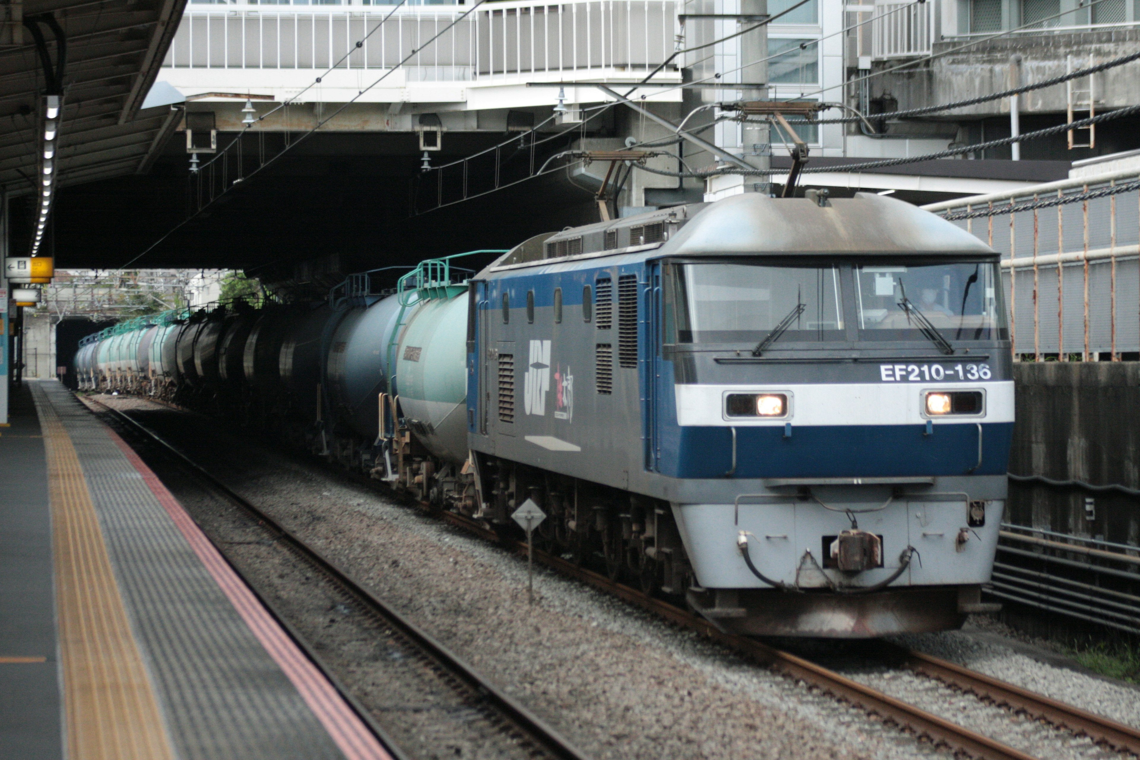 Train de marchandises bleu arrivant à une gare