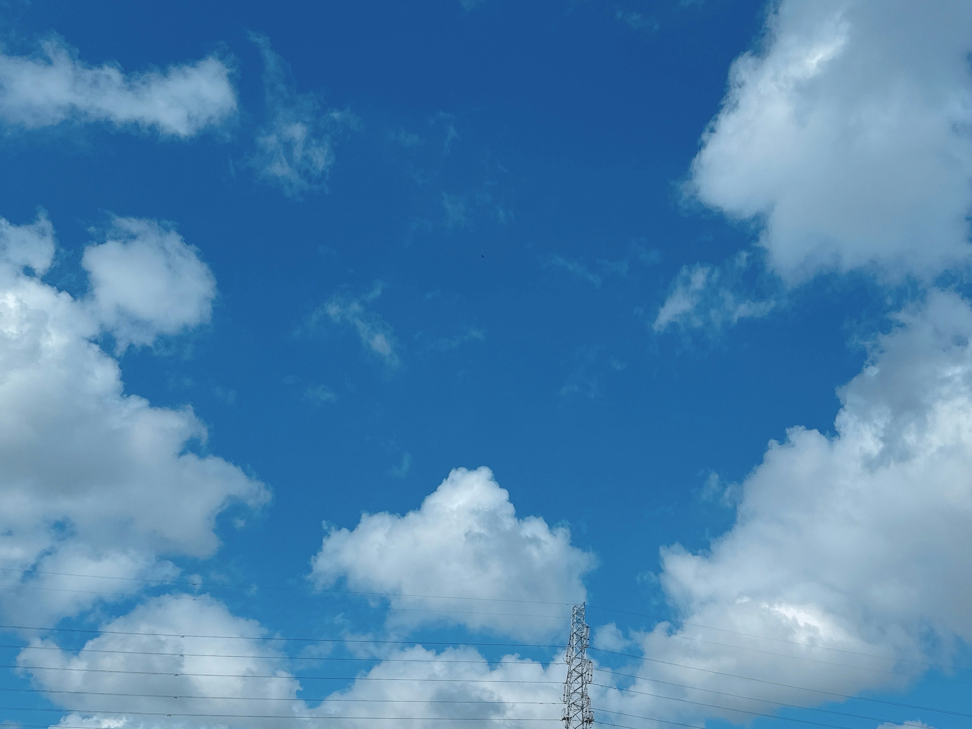 A clear blue sky with fluffy white clouds