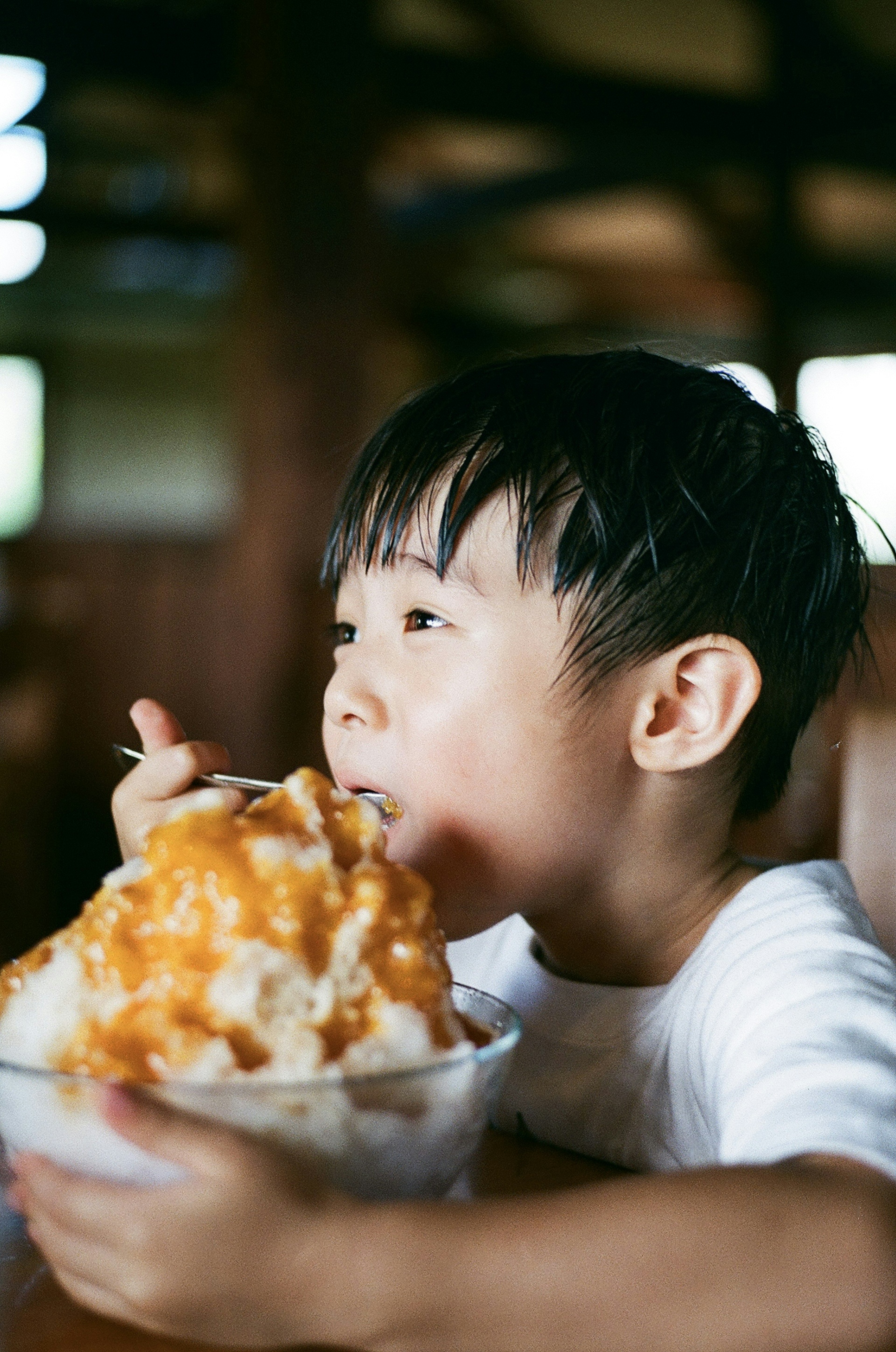 Un bambino che gusta una grande ciotola di ghiaccio tritato