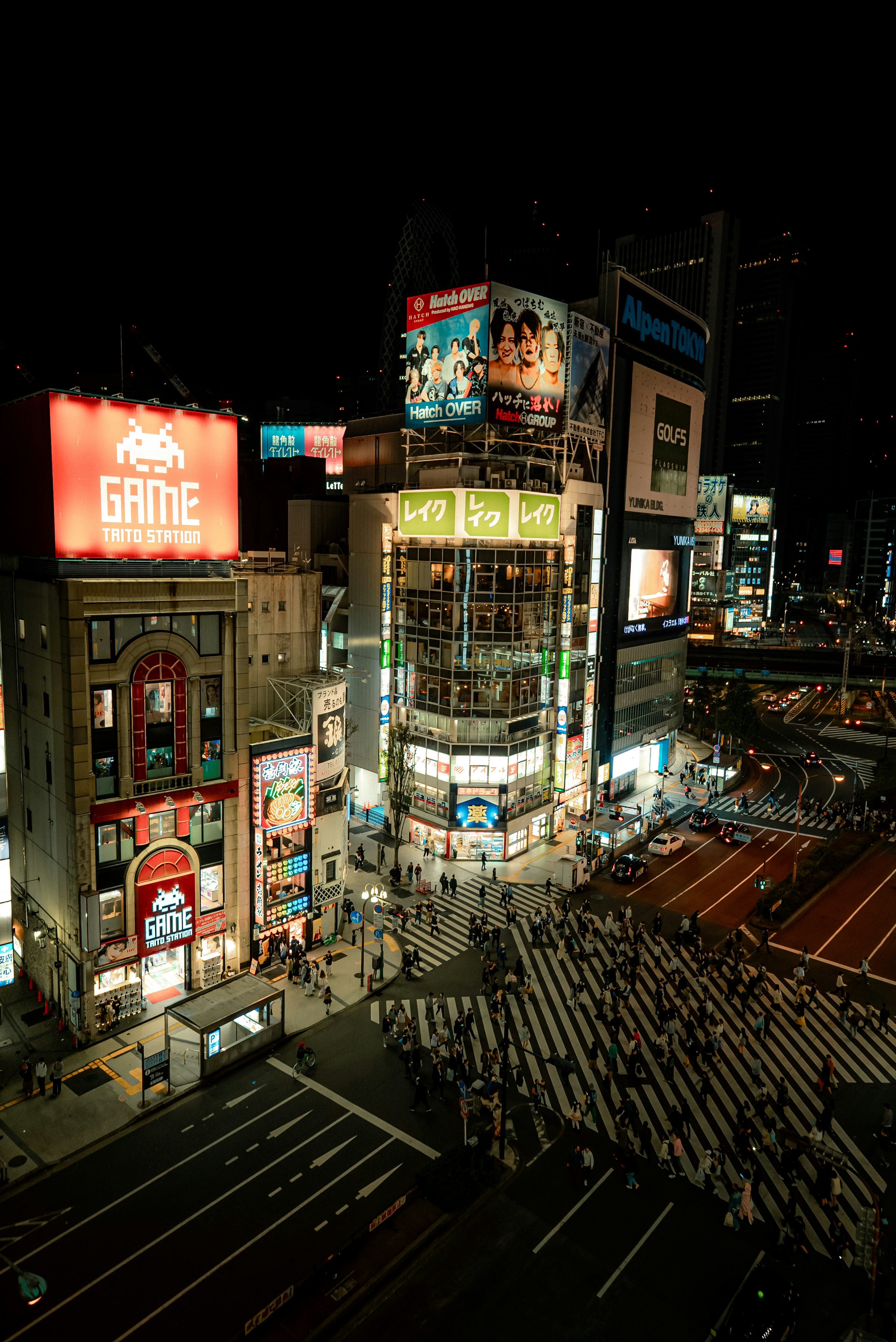 Belebte Shibuya-Kreuzung bei Nacht mit Neonlichtern