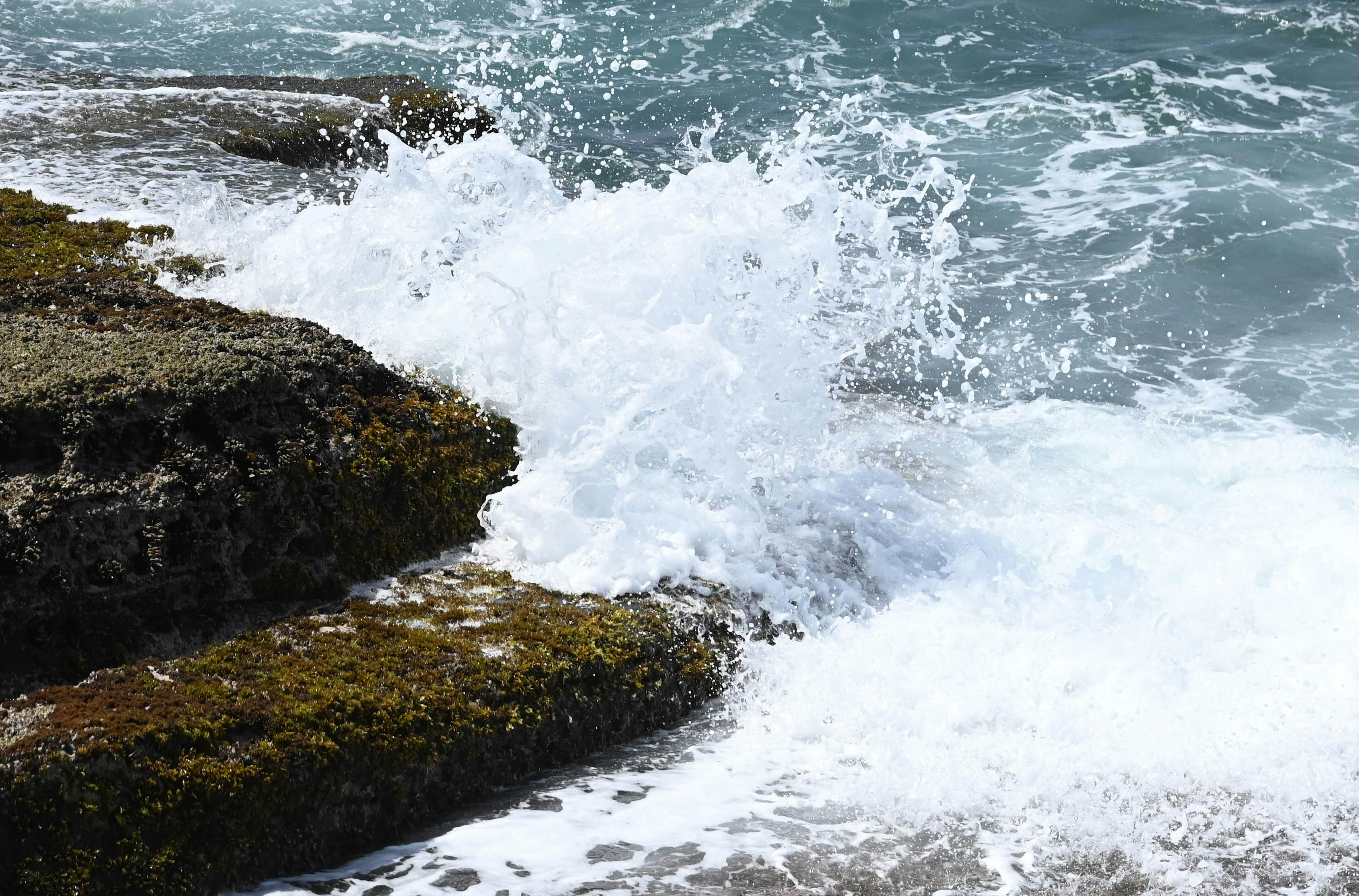 海浪撞擊岩石的景象，伴隨海泡