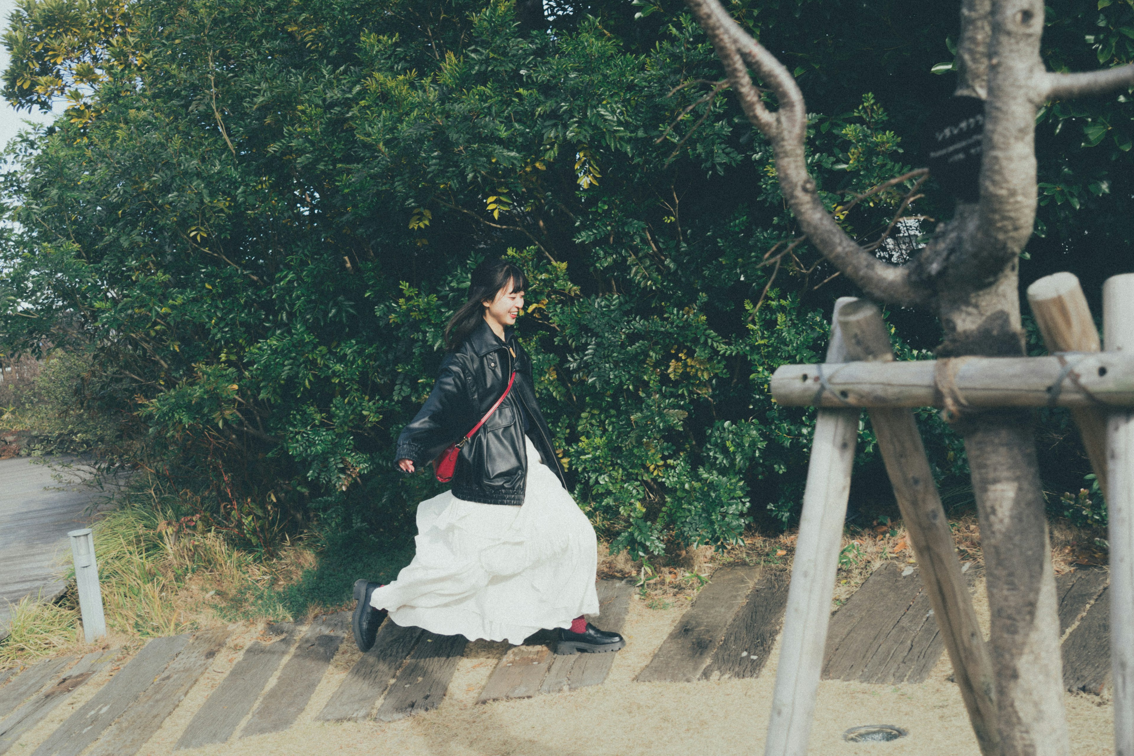 A woman in a white outfit running between trees