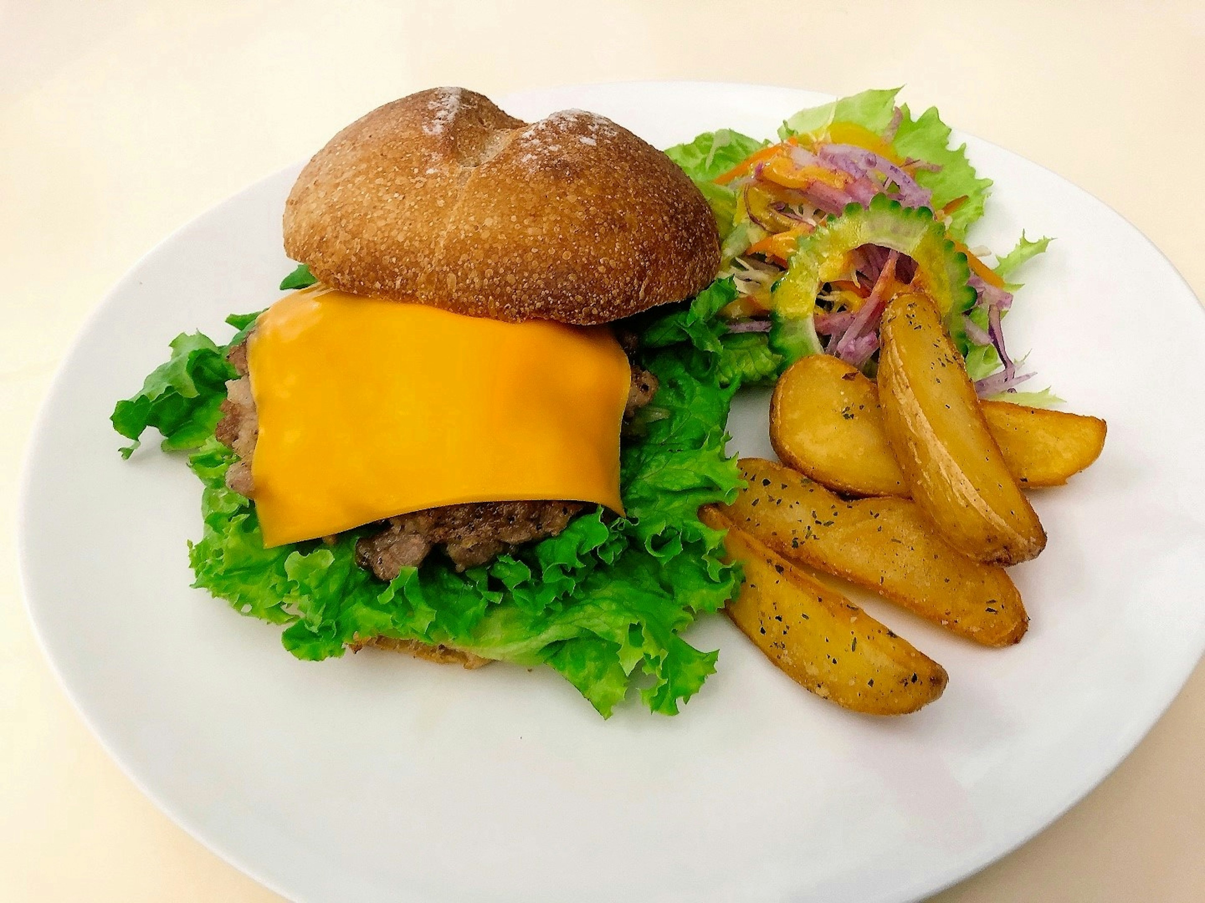 Cheeseburger con lattuga e contorno di patate a spicchi