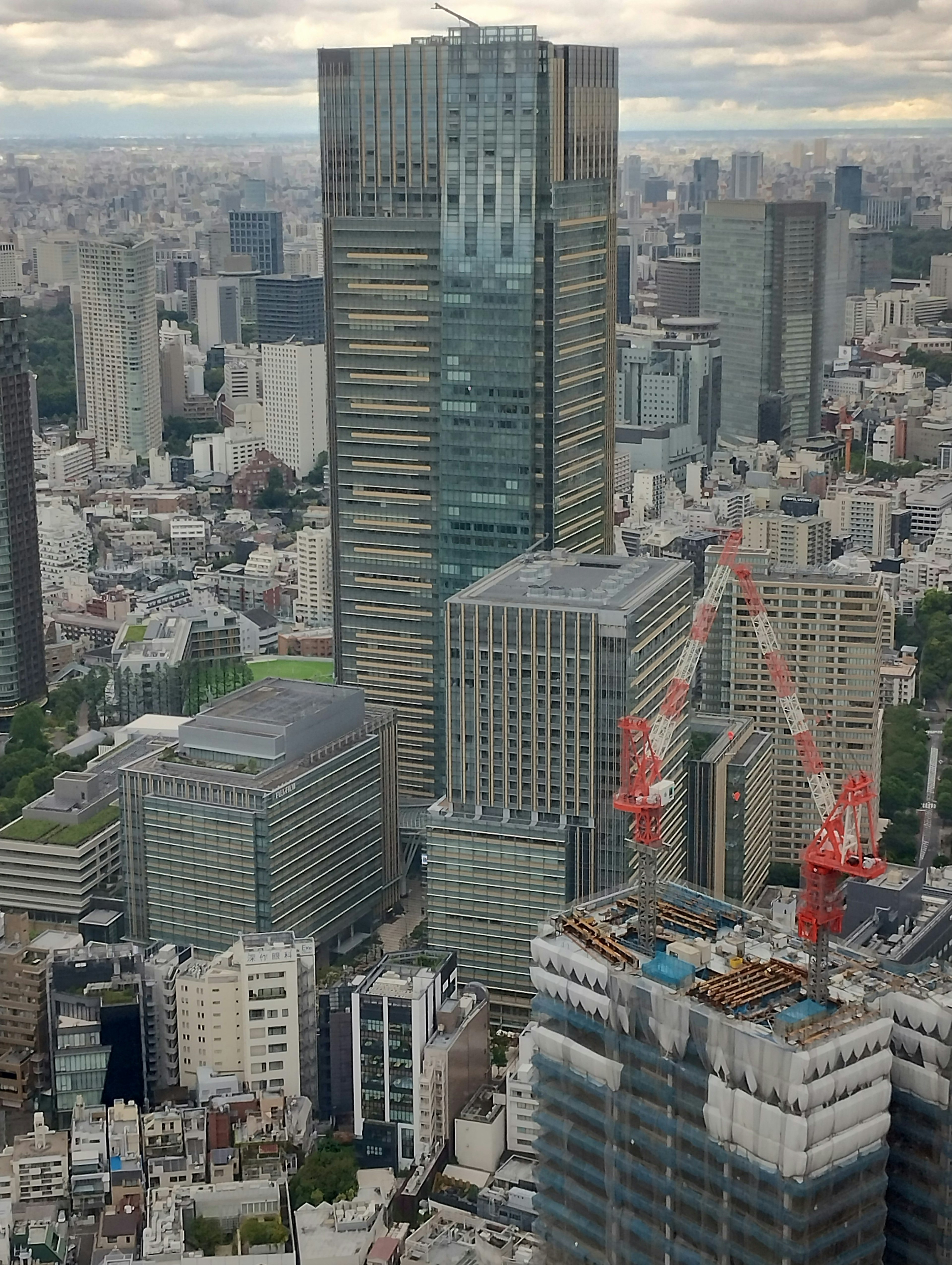 東京天際線的鳥瞰圖，特色是現代摩天大樓和施工起重機